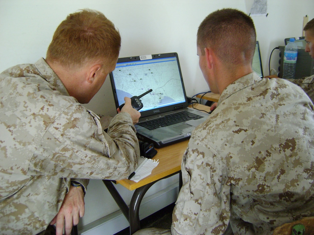 Maj. Rafael Maryahin, the battalion commander of a simulated Marine Corps infantry battalion, uses the antenna of his radio to point out a specific location to Marine Air Ground Task Force Tactical Warfare Simulation terminal operator Lance Cpl. Chris R. Trader May 26 during the command post exercise of African Lion 2011. The Marines, both of 4th Combat Engineer Battalion, 4th Marine Division, a Marine Corps reserve unit headquartered in Baltimore, participated in the nine-day command post exercise with counterparts from the Royal Moroccan Armed Forces in order to increase interoperability of the two nations’ militaries.::r::::n::