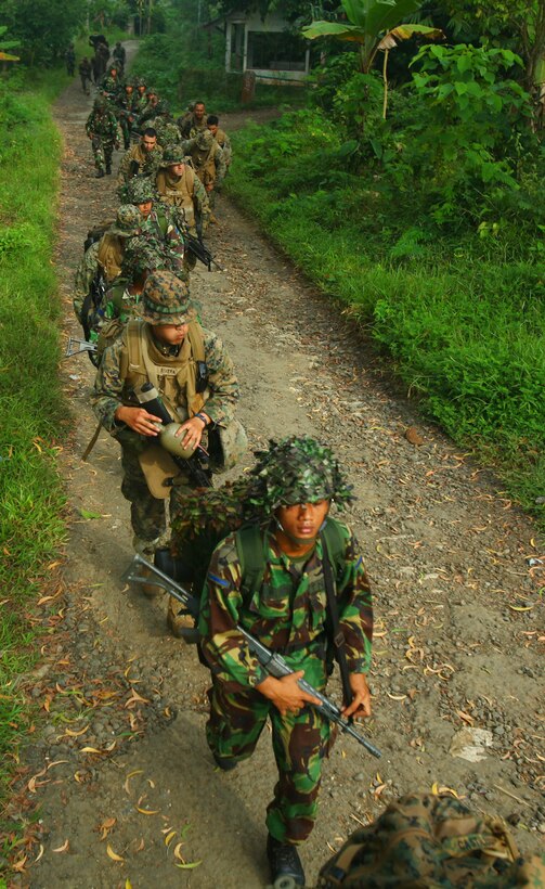 Marines and Sailors from Landing Force Company and Indonesian Marines from 6th Battalion, 2nd Brigade, Korps Marinir, make their way to martial arts training May 27. Landing Force Company, comprised primarily of Marines from 2nd Battalion, 23rd Marine Regiment and 4th Assault Amphibian Battalion, 4th Marine Division, is participating in Cooperation Afloat Readiness and Training (CARAT) 2011. CARAT is an annual series of bilateral exercises held between the U.S. and Southeast Asian nations with the goals of enhancing regional cooperation, promoting mutual trust and understanding, and increasing operational readiness.  While in Indonesia, the service members from both nations will train together on martial arts, military operations on urban terrain, jungle warfare, combat marksmanship and combat lifesaving. (U.S. Marine Corps Photo by Cpl. Aaron Hostutler)