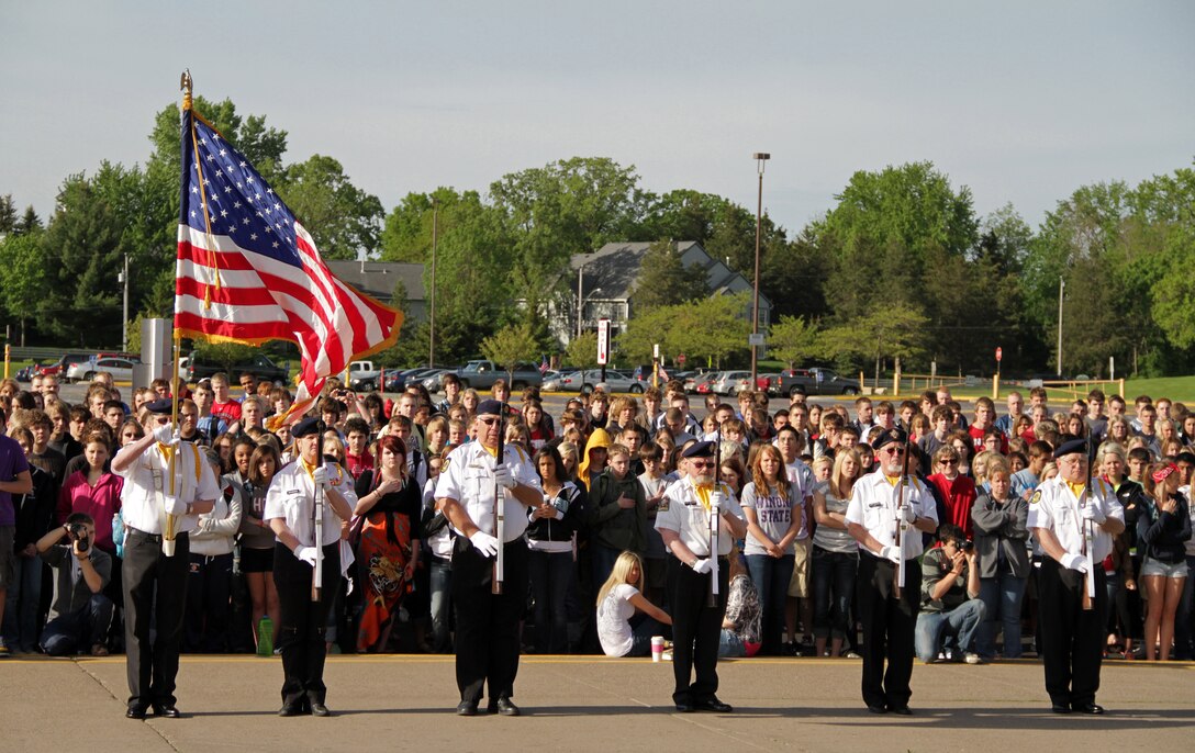 Hudson High School's entire student body watches members from American Legion Post 50 present the Colors during the Empty Parking Lot Project ceremony May 27, an event dedicated to honoring all service members, past and present. Four Marines with Recruiting Substation Woodbury also attended the gathering. For additional imagery from the event, visit www.facebook.com/rstwincities.