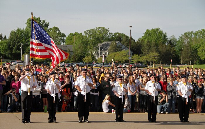 Hudson High School's entire student body watches members from American Legion Post 50 present the Colors during the Empty Parking Lot Project ceremony May 27, an event dedicated to honoring all service members, past and present. Four Marines with Recruiting Substation Woodbury also attended the gathering. For additional imagery from the event, visit www.facebook.com/rstwincities.