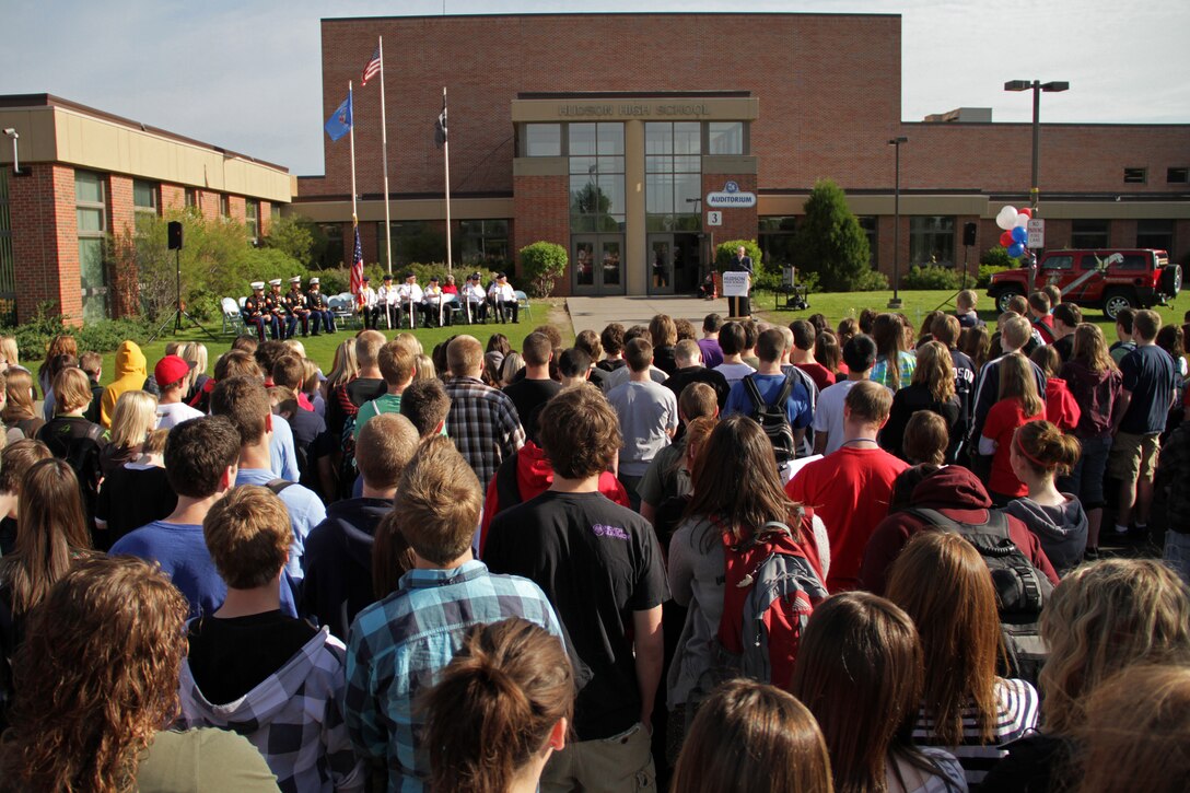 Faculty members and the entire student body gather outside of Hudson High School for the Empty Parking Lot Project ceremony May 27, an event dedicated to honoring all service members, past and present. To show their appreciation and recognize the sacrifices made by men and women serving at home and abroad, students emptied the school's parking lot by walking, riding bikes or taking the bus to school. For additional imagery from the event, visit www.facebook.com/rstwincities.::r::::n::