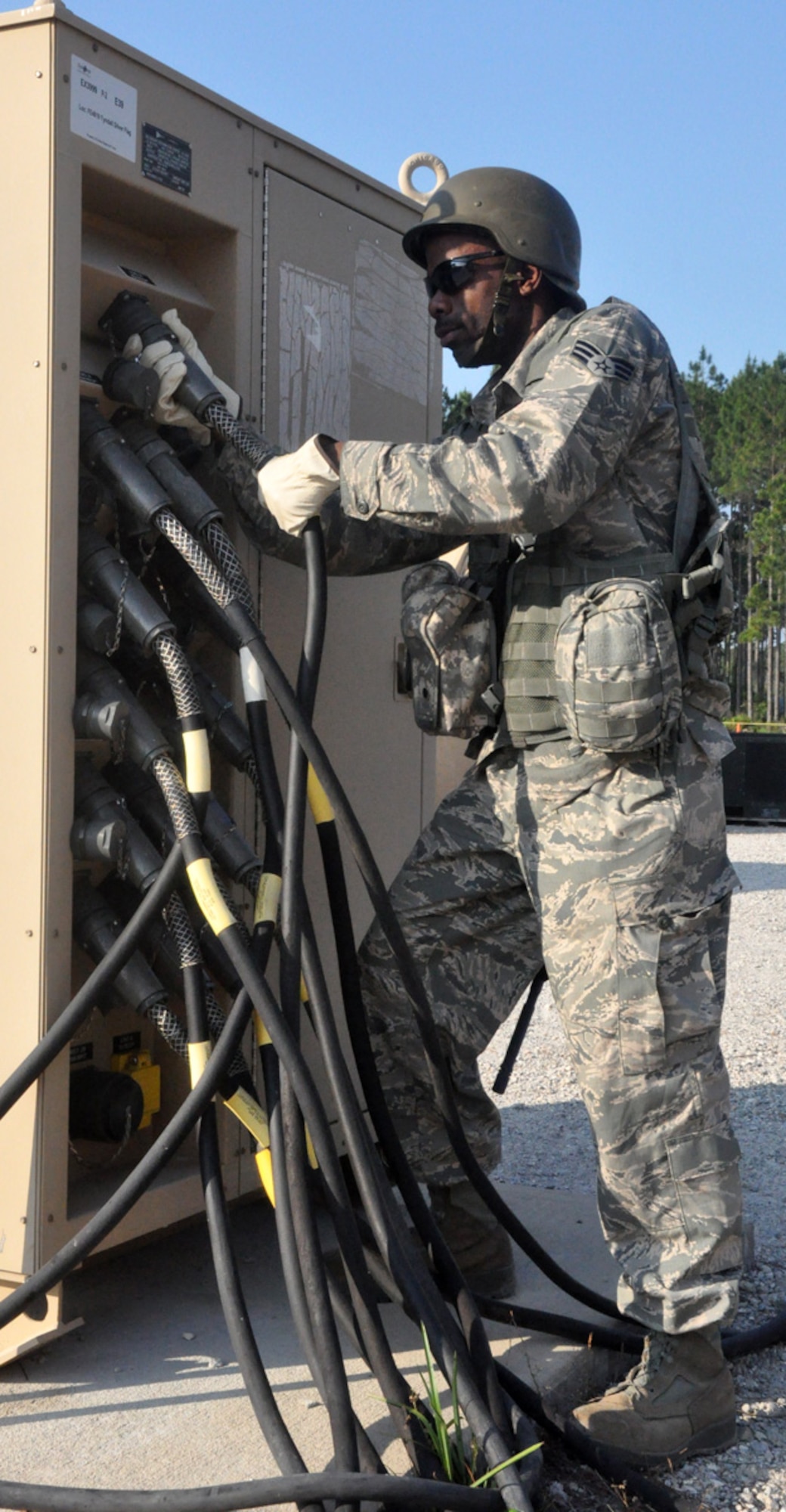 U.S. Air Force Senior Airman Ernest Munns from the 446th Civil Engineer Squadron connects a large cannon plug on a secondary distribution center used to supply electrical power to entire bare base tent cities during a field exercise at Tyndall Air Force Base, Fla. on May 24, 2011. Airman Munns is one of 30 Reservists from the 446th CES participating in Silver Flag 2011, a week-long training exercise designed to improve the readiness capability of Air Force civil engineers. Airman Munns is a father of three children, and works as a cable installer with Comcast in his civilian life. (U.S. Air Force photo by Staff Sgt. Grant Saylor/Released)