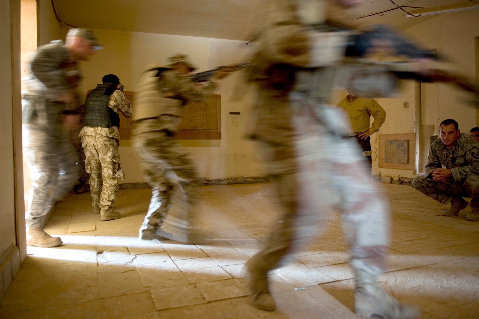 Iraqi security forces members storm a room as Air Force trainers with the 447th Expeditionary Security Forces Squadron evaluate their tactics May 23, 2011, at Sather Air Base, Iraq. The Iraqi service members were undergoing advanced security forces training to prepare for personal security detail training. (U.S. Air Force photo/Staff Sgt. Levi Riendeau)