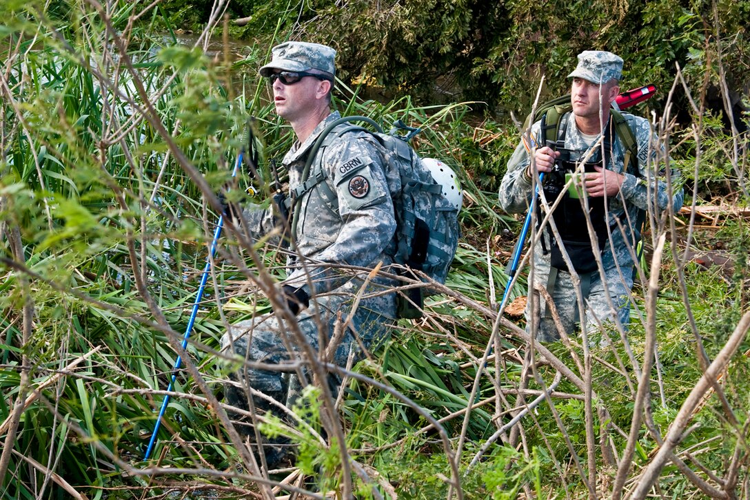 Army Sgt 1st Class Jared Hallmark, left, and Master Sgt. Ken Perry, search a ravine for a 3-year-old missing boy after a deadly tornado near Piedmont, Okla., May 24, 2011. Hallmark and Perry are members of the 63rd Civil Support Team, Oklahoma National Guard.