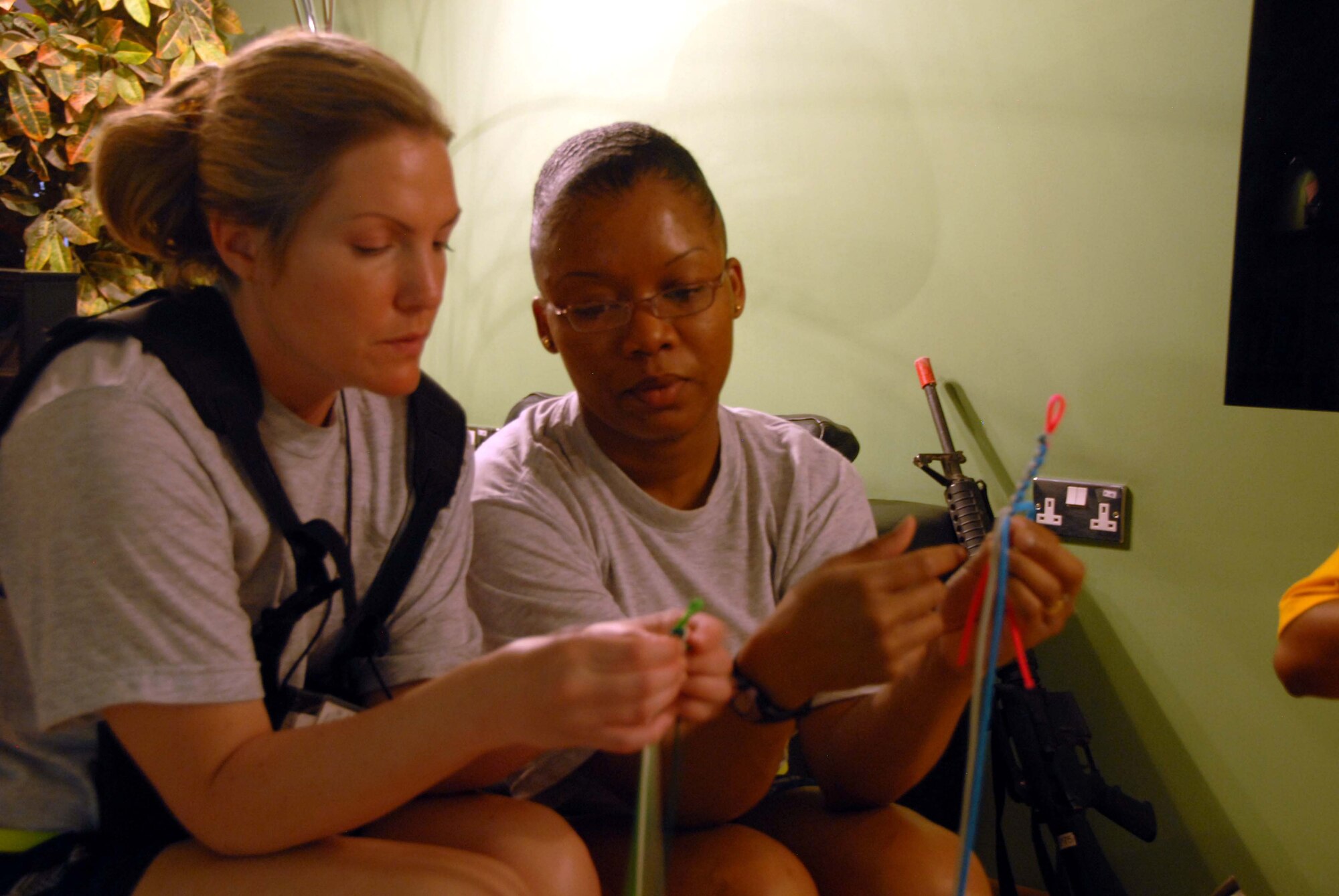 Technical Sergeants Tomsanna Farley and Renee Williams make bracelets at Kandahar Airfield on May 22. The bracelets will be sent to the United States as gifts. Both Sergeant Farley and Sergeant Williams volunteer at the USO on their day off from work at the 451st Air Expeditionary Wing. (U.S. Air Force photo by Tech. Sgt. Emily F. Alley)