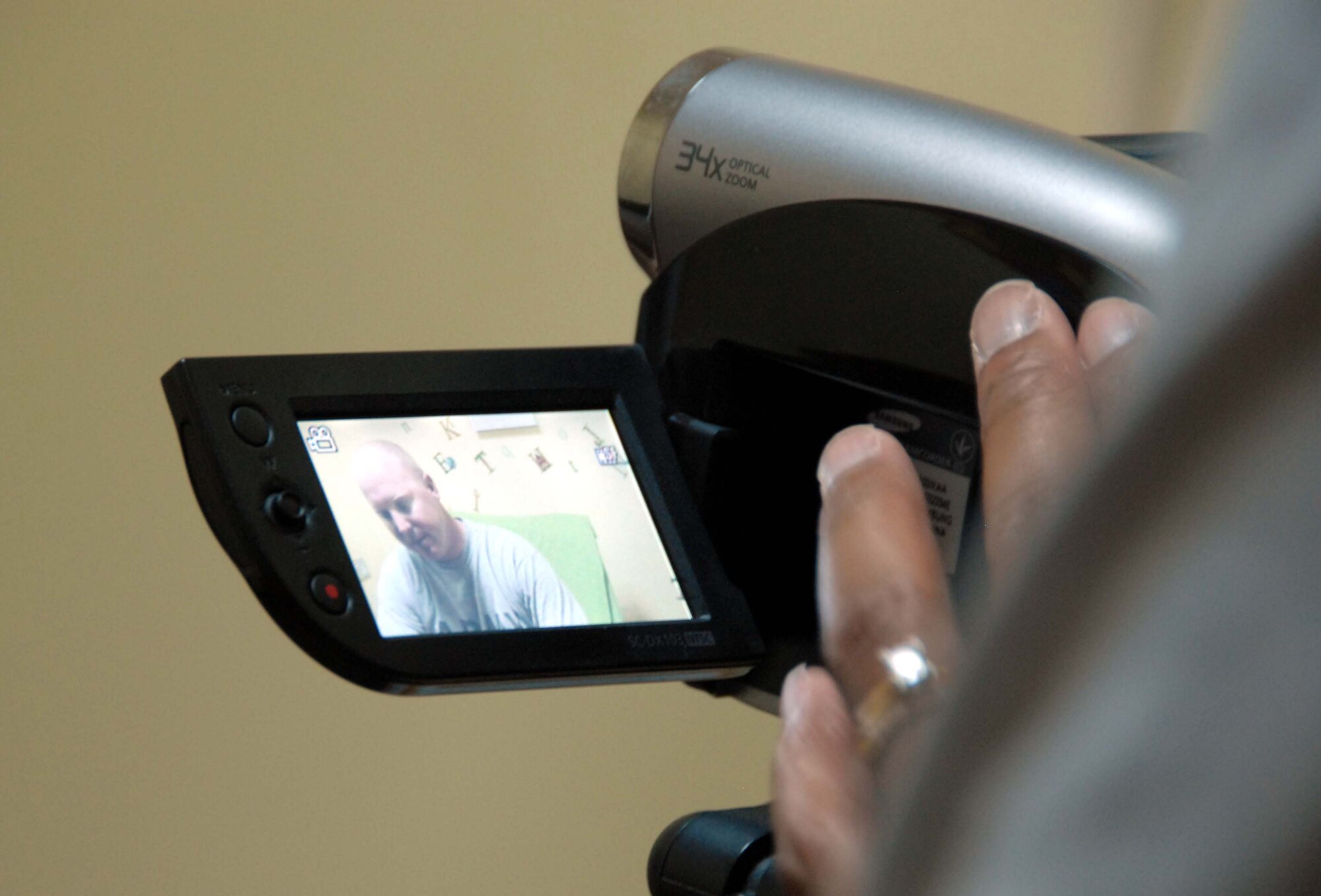 Tech. Sgt. Renee Williams sets up a camera to record a soldier who is preparing to read a book at Kandahar Airfield, Afghanistan on May 22. Sergeant Williams volunteers on her day off to help deployers read donated books to their friends and families at home. She is assigned to the 451st Air Expeditionary Wing at the airfield. (U.S. Air Force photo by Tech. Sgt. Emily F. Alley)