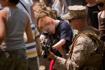EAST MEADOW, N.Y. - A Marine teaches a child about a rifle after a helicopter raid demonstration at Eisenhower Park May 28. The demonstration was held by Marines with the 24th Marine Expeditionary Unit as part of Fleet Week New York 2011. More than 3,000 Marines, sailors and Coast Guardsmen are participating in community events and demonstrations as part of Fleet Week. This is the 27th year New York has hosted the sea services for Fleet Week. (Official Marine Corps photo by Sgt. Randall A. Clinton / RELEASED)