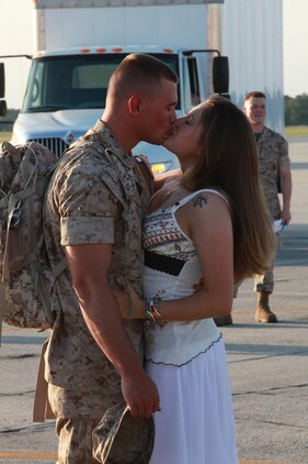 Cpl. Keith Peffer, an ordnance technician for Marine Fighter Attack Squadron 122, kisses his wife, Ashley after landing on the flightline May 29. The families and children are affected by each deployment as much or more so then the Marine who is forward and completng the mission.::r::::n::::r::::n::::r::::n::