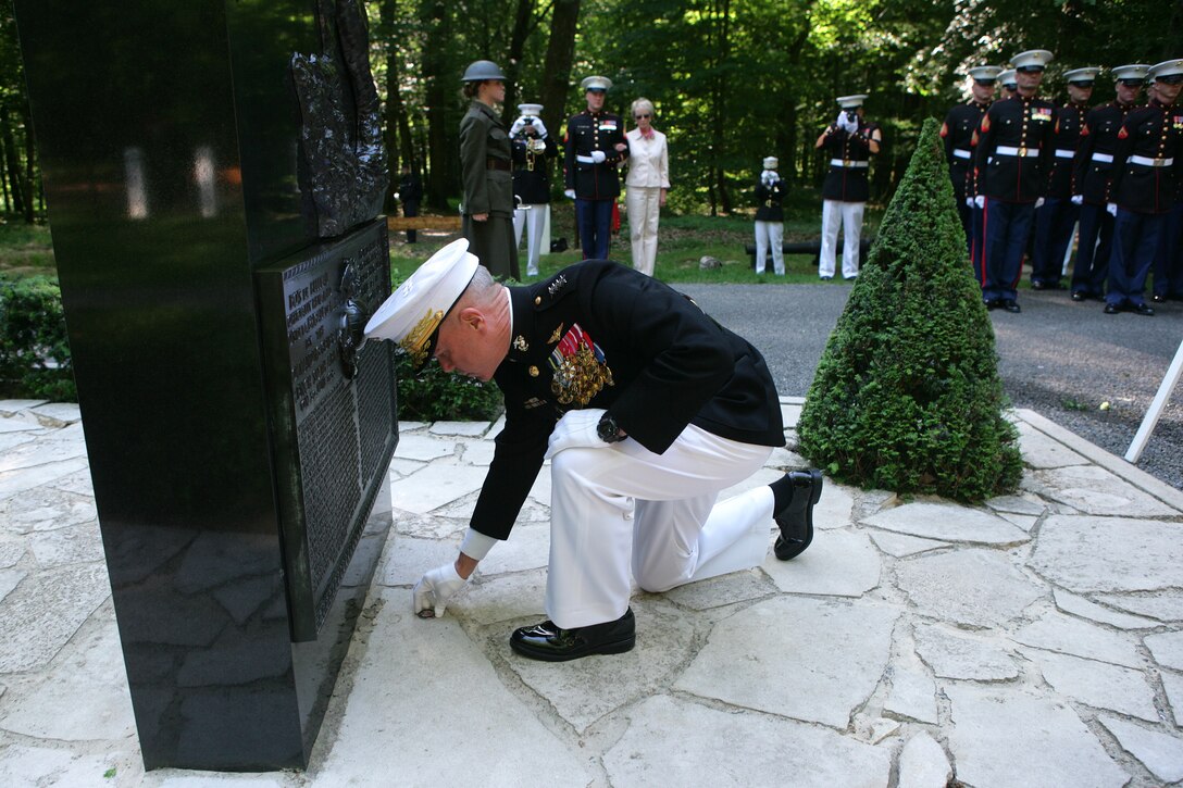 The 35th Commandant of the Marine Corps General James F. Amos lays a commemorative coin in front of the Iron Mike monument atop a hill in the heart of the Belleau Wood forest during a private Memorial Day ceremony in front of a formation of Marines and French soldiers. The coin is from the Marines of Task Force Belleau Wood, assigned to II Marine Expeditionary Force (Forward) in Regional Command (Southwest) in Afghanistan. The coin was given to the Commandant during his visit to Afghanistan, May 11-15, 2011.