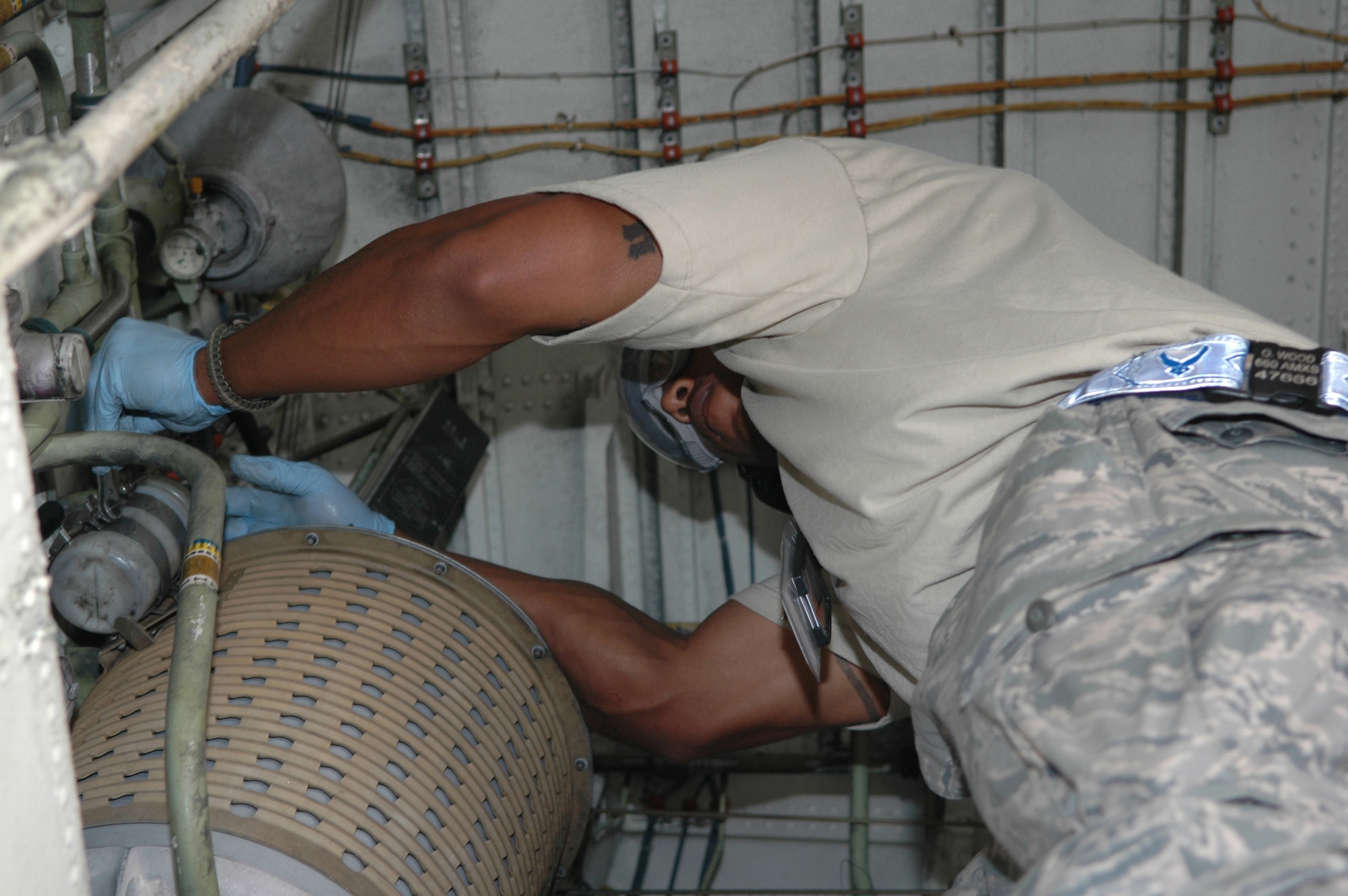 Staff Sgt. Olajuwon Wood, 380th Expeditionary Aircraft Maintenance Squadron KC-10 Extender crew chief supervisor, inspects the hydraulics system in the wheel well during a maintenance check in Southwest Asia. Sergeant Wood is deployed from the 660th AMXS, Travis AFB, Calif. (U.S. Air Force photo by Master Sgt. Julie Briden-Garcia)