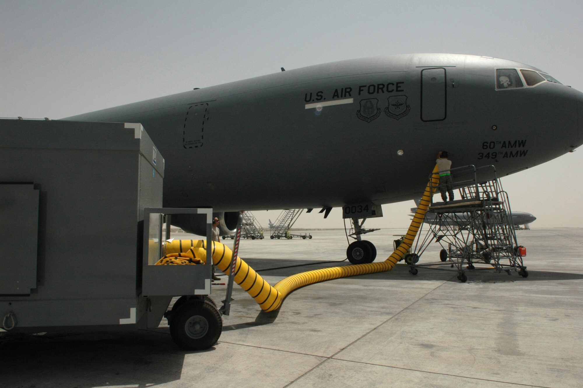 Airman 1st Class Gene Meredith, 380th Expeditionary Aircraft Maintenance Squadron KC-10 Extender crew chief, seals an air cart hose to the side of the aircraft in Southwest Asia. One hour prior to the air crew's arrival, the air carts help prevent the tanker's internal electrical components from overheating during extreme temperatures in the Area of Responsibility. Airman Meredith is deployed from 605th AMXS, McGuire AFB, N.J. (U.S. Air Force photo by Master Sgt. Julie Briden-Garcia)