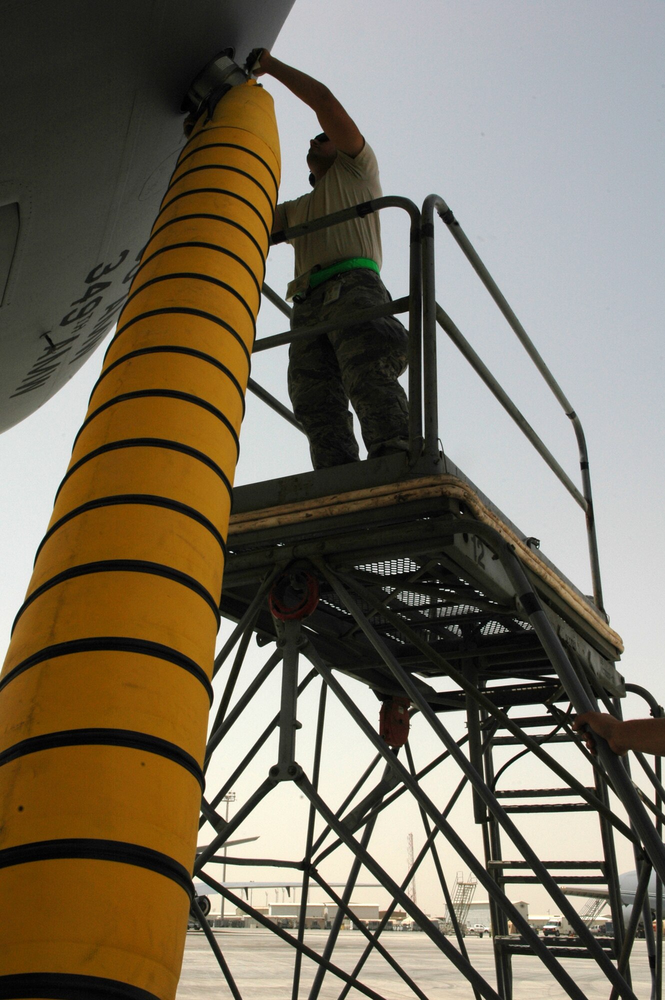 Airman 1st Class Matthew Haynes, 380th Expeditionary Aircraft Maintenance Squadron crew chief for the KC-10 Extender, seals an air cart hose to the side of the aircraft in Southwest Asia. One hour prior to the air crew's arrival, the air carts help prevent the tanker's internal electrical components from overheating during extreme temperatures in the Area of Responsibility. Airman Haynes is deployed from 605th AMXS, McGuire AFB, N.J. (U.S. Air Force photo by Master Sgt. Julie Briden-Garcia)