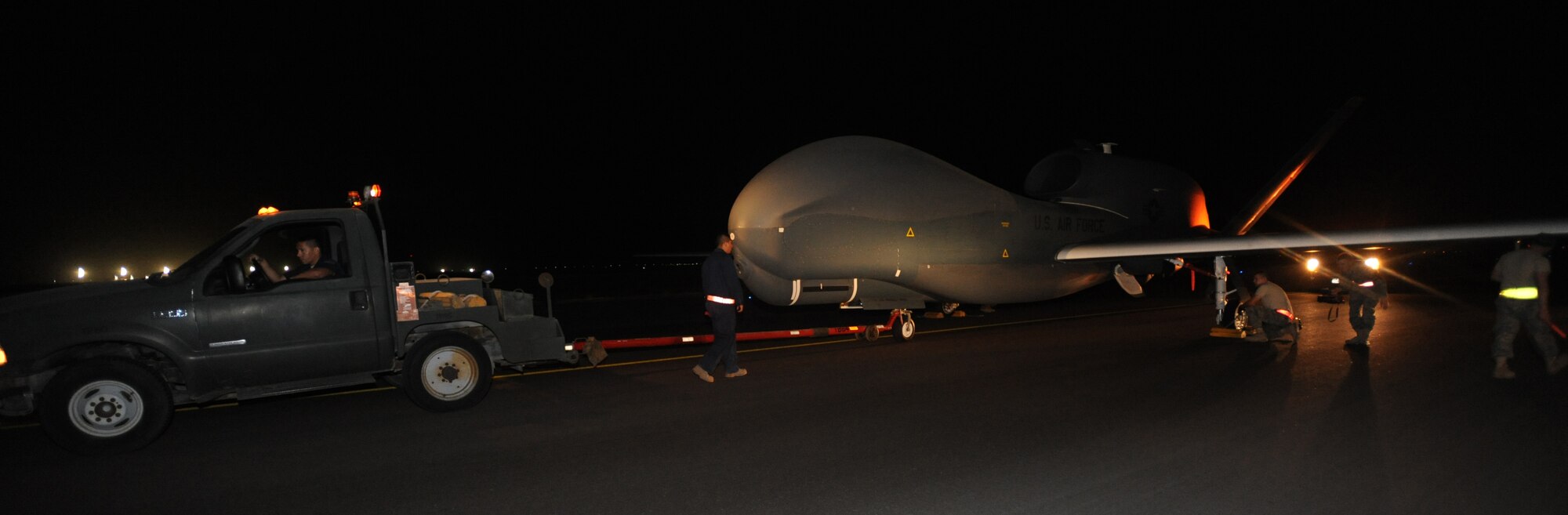 Crew chiefs from the 380th Expeditionary Aircraft Maintenance Squadron, tow in the newest addition to the 380th Air Expeditionary Wing’s airframes, an RQ-4B Global Hawk, shortly after its arrival May 11, 2011, in Southwest Asia. The RQ-4B model outperforms its predecessor with a 50 percent increase in payload capacity of 3,000lbs and operates with 2.5 times more electrical power. (U.S. Air Force photo by Senior Airman Maynelinne De La Cruz)