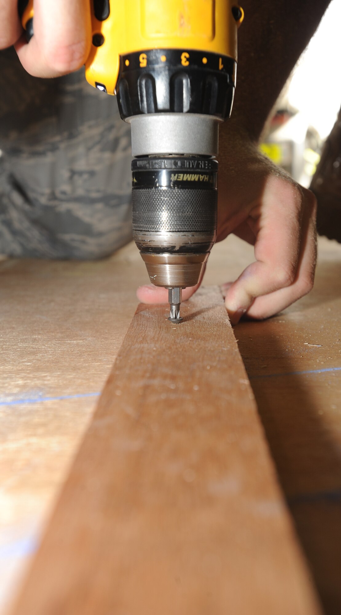Building a roof for the Fire Suppression Unit System pump house, one of the 380th Expeditionary Civil Engineers use a power drill to connect wood boards together April 18, 2011, in Southwest Asia. Civil engineers work 50 to 75 projects a week from building new facilities to adjusting doors.  (U.S. Air Force photo by Senior Airman Maynelinne De La Cruz)  