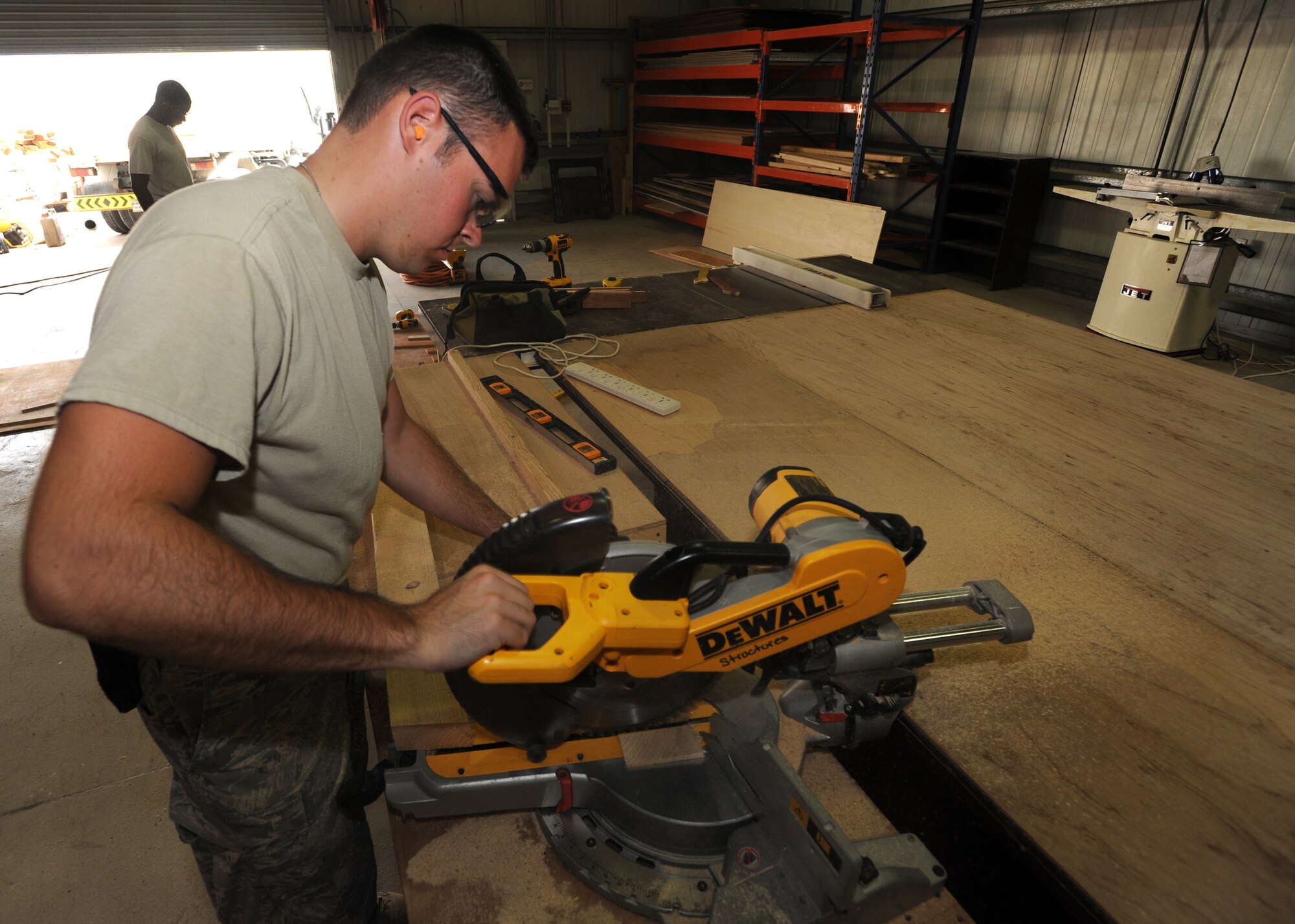 Senior Airman Chris Fehringer, 380th Expeditionary Civil Engineer Squadron, cuts a piece of wood using a miter saw for the Fire Suppression Unit System pump house roof April 18, 2011, in Southwest Asia. Civil engineers work 50 to 75 projects a week from building new facilities to adjusting doors.  (U.S. Air Force photo by Senior Airman Maynelinne De La Cruz)  