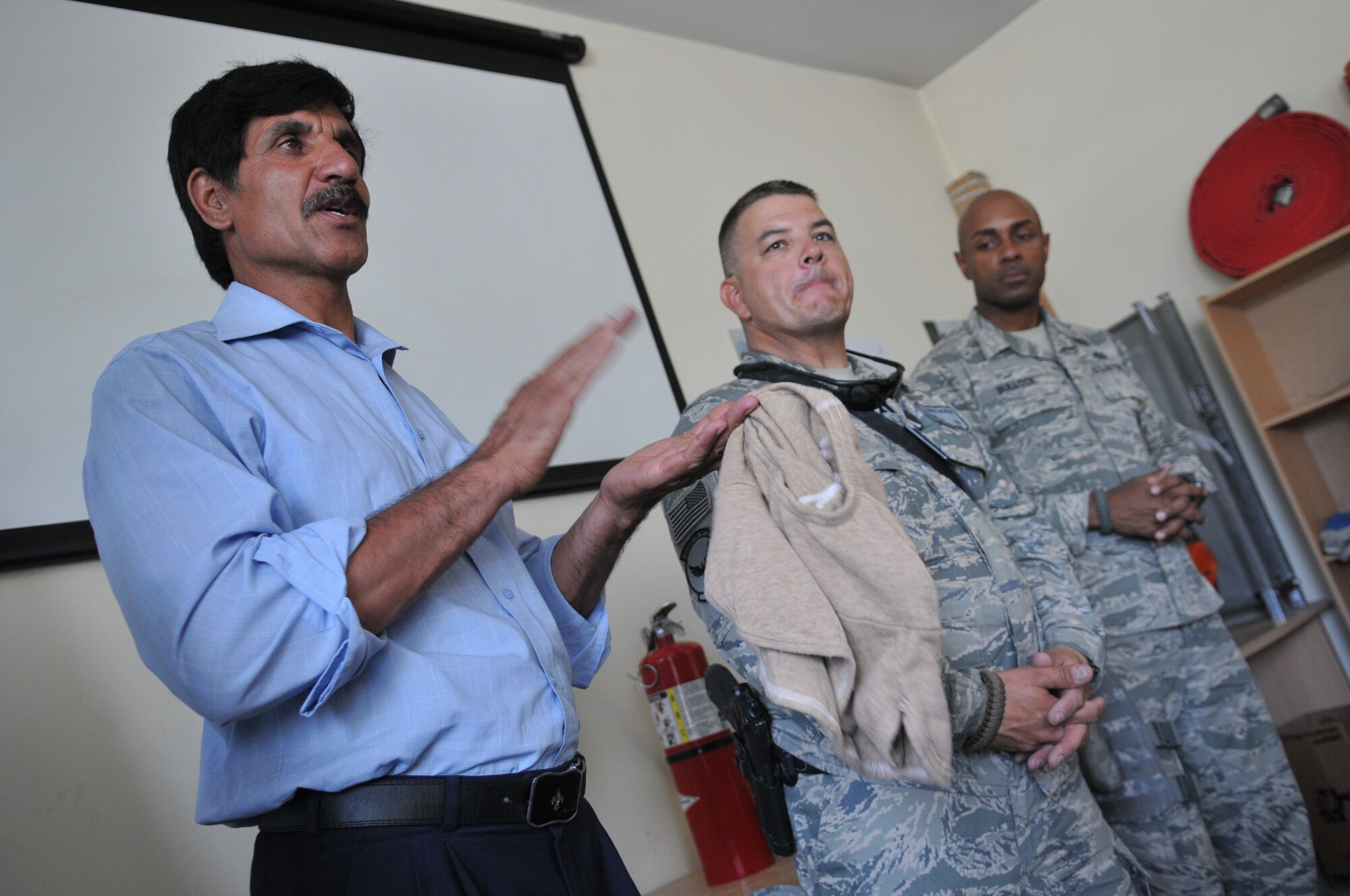 KABUL, Afghanistan -- Sadar Ahmad, Afghan fire fighter instructor thanks Master Sgt. Edward Nowak, 440th Air Expeditionary Advisory Squadron C-27 production superintendant advisor and volunteer firefighter, for the donated Nomex fire protection hoods to trainees inside the Afghan Air Force fire fighting training complex. The hoods were donated by the Robeson County Firefighters Association located in Parkton, N.C. (US Air Force Photo by Tech. Sgt. Brian E. Christiansen)
