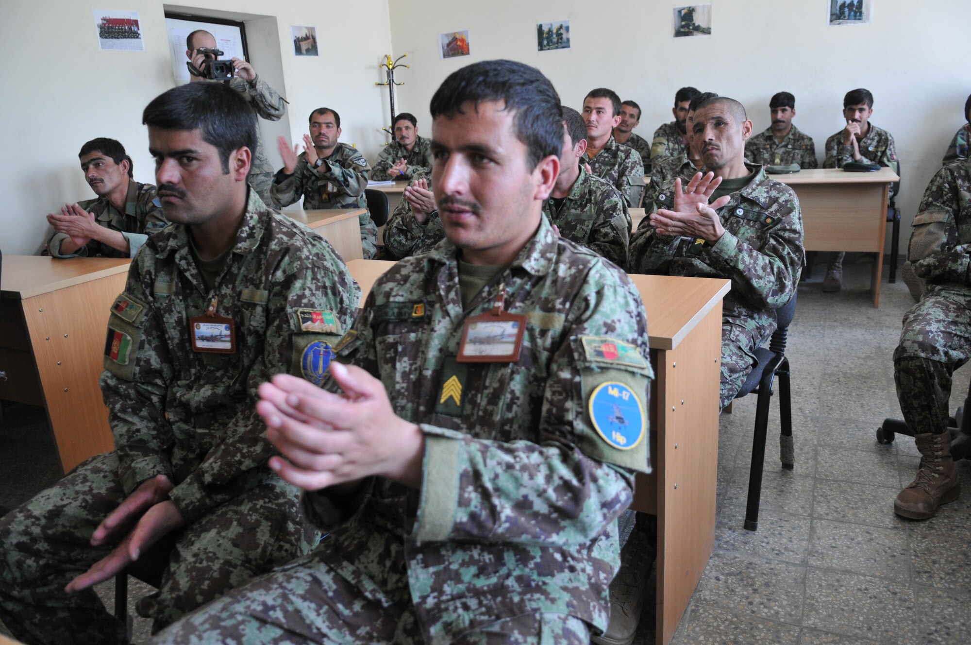 KABUL, Afghanistan -- Afghan firefighter trainees show their excitement after Master Sgt. Edward Nowak, 440th Air Expeditionary Advisory Squadron C-27 production superintendant advisor and volunteer firefighter, presented Nomex fire protection hoods inside the Afghan Air Force fire fighting training complex. The Nomex hoods were donated by the Robeson County Firefighters Association located in Parkton, N.C. (US Air Force Photo by Tech. Sgt. Brian E. Christiansen)
