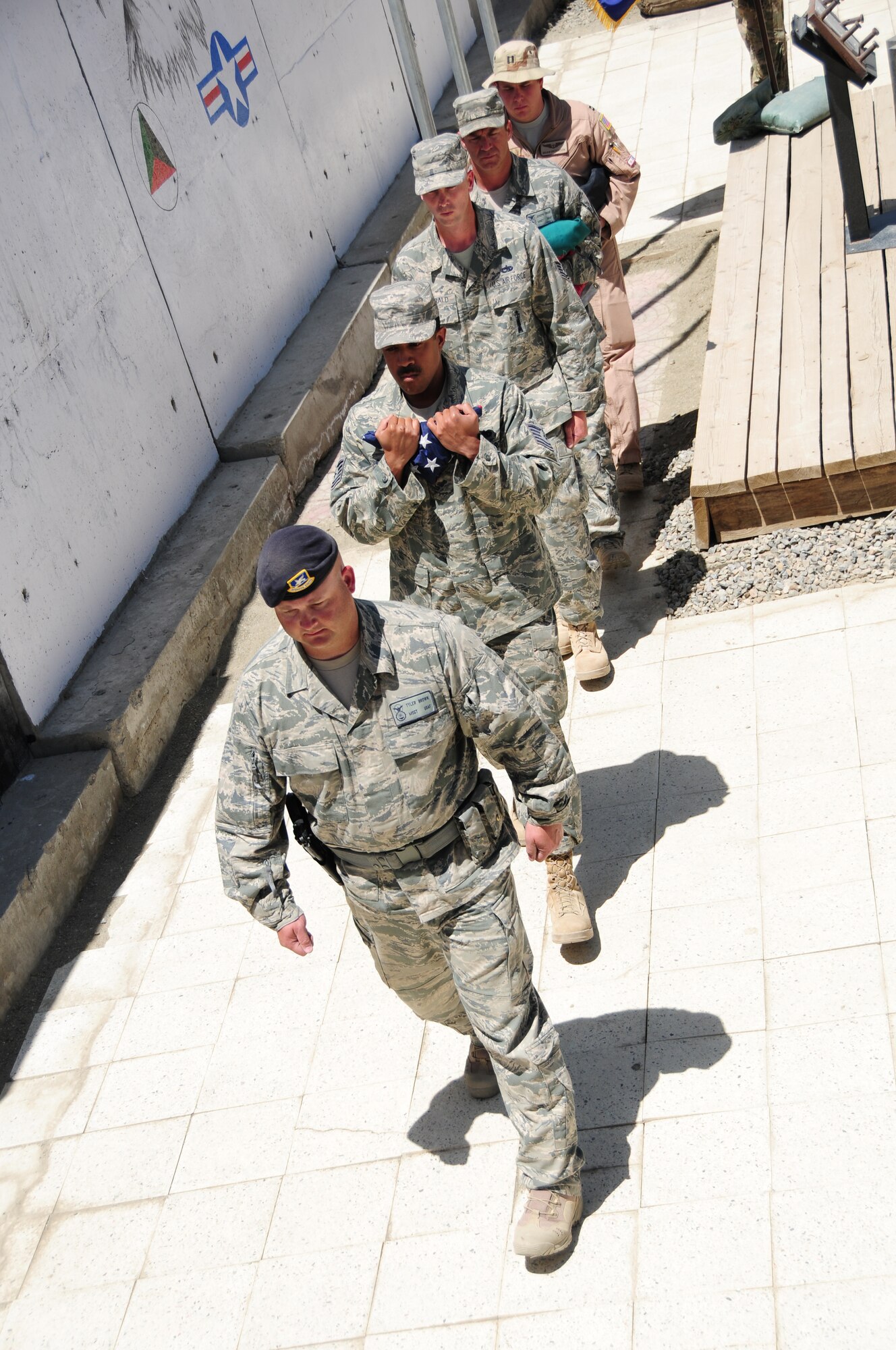 U.S. Air Force Airmen from the 438th Air Expeditionary Wing recover the flag from the Memorial Day ceremony in Kabul, May 30, 2011. The ceremony recognized fallen service members including the eight airmen and DOD contractor killed here April 27th. (U.S. Air Force photo by Senior Airman Amber Williams)