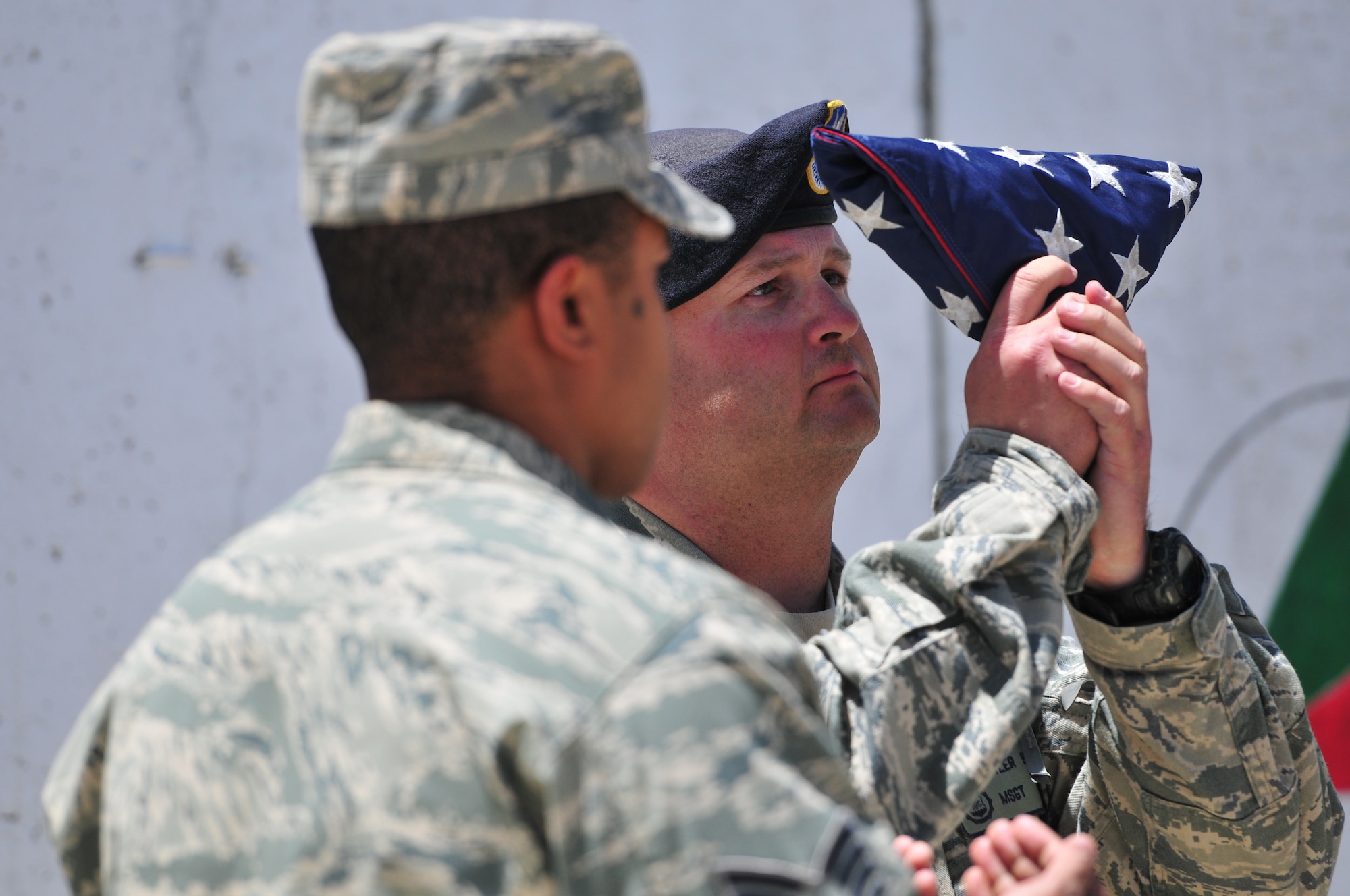 KABUL, Afghanistan - Master Sgt. Tyler Brown, 738th Air Expeditionary Advisory Squadron, inspects the flag after it was folded during a ceremony to commemorate Memorial Day.  The day serves to honor military members currently serving and those that have died while in military service.  Many Americans observe Memorial day by visiting cemeteries and memorials with the U.S. flag usually flying at half staff.  (US Air Force Photo by Tech. Sgt. Brian E. Christiansen)