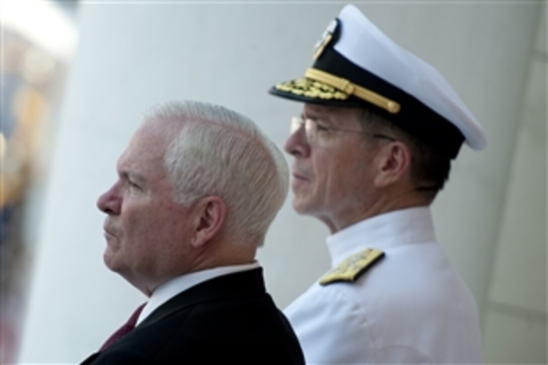 Defense Secretary Robert M. Gates and  Navy Adm. Mike Mullen, chairman of the Joint Chiefs of Staff, listen to President Barack Obama's remarks during the Memorial Day commemoration ceremonies at Arlington National Cemetery in Arlington, Va., May 30, 2011. 
