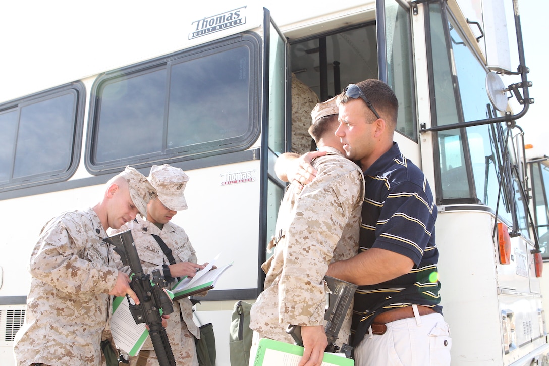 Cpl. David Capuzzo, a Military Working Dog handler with the 3rd Marine Expeditionary Force, who is part of the unit’s remain behind element, hugs every deploying Marine as they board the bus enroute to Afghanistan from the Combat Center  May 31, 2011.