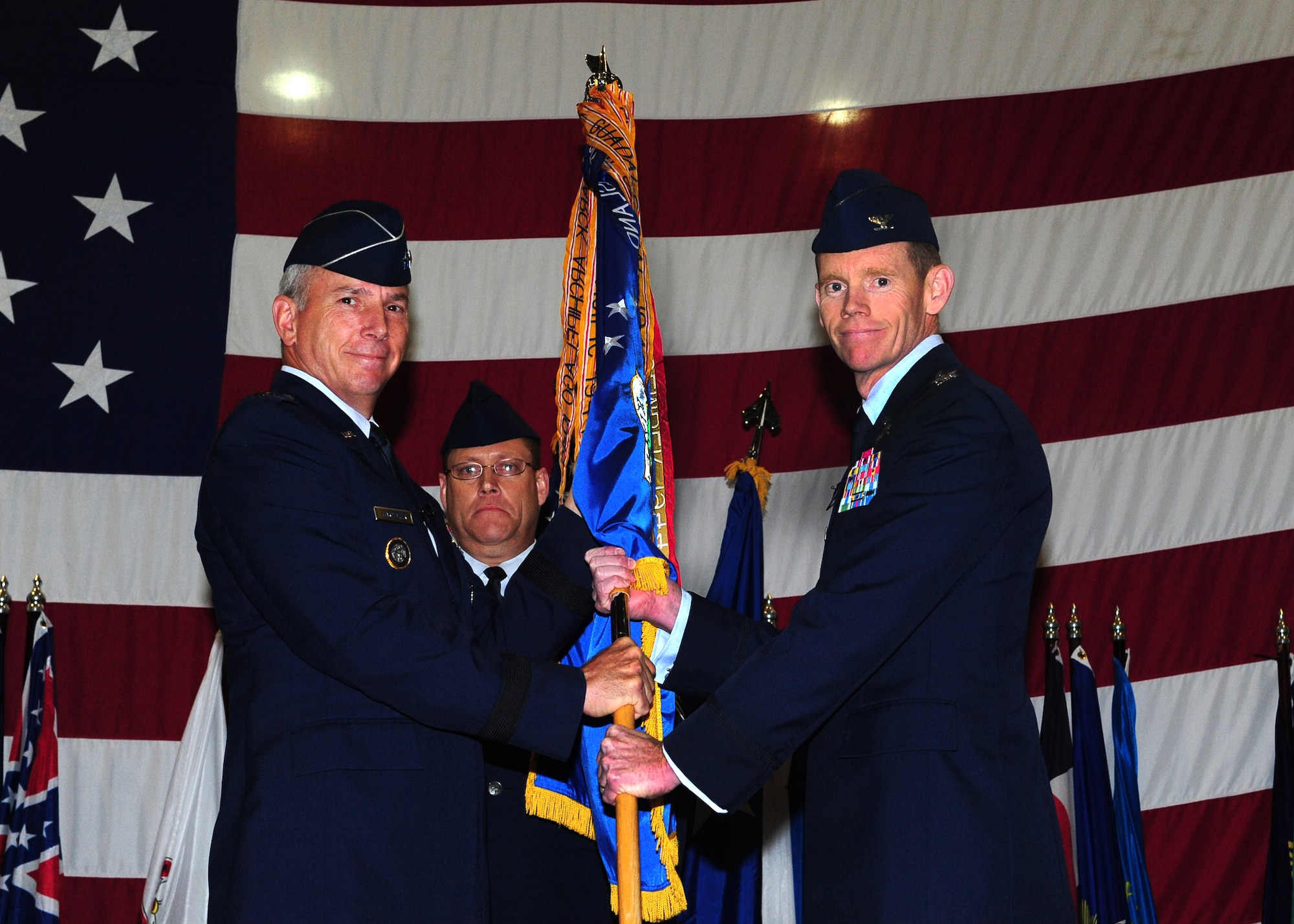 MINOT AIR FORCE BASE, N.D. -- Maj. Gen. Floyd Carpenter, 8th Air Force commander, passes the 5th Bomb Wing guidon to Col. James Dawkins as he assumes command May 31.  Colonel Dawkins will lead as the 51st commander of the 5th Bomb Wing “Warbirds.” The change of command ceremony is one of the Air Force’s time-honored traditions. (U.S. Air Force photo/Senior Airman Michael J. Veloz)