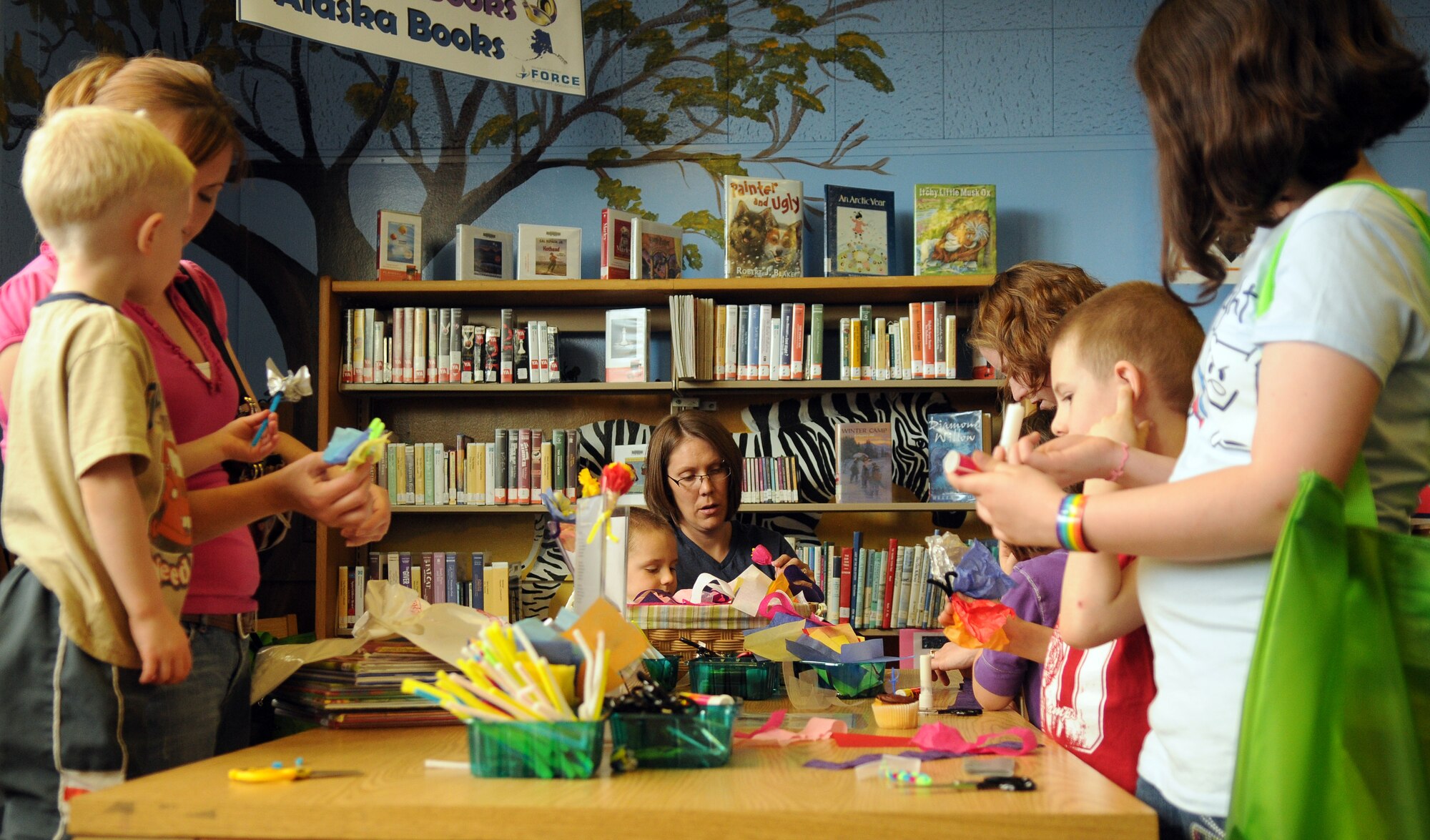 Families create decorations at the arts and crafts table in the base library, March 24, 2011, Eielson Air Force Base, Alaska. Various activities and programs are planned for children during the summer including weekly arts and crafts. (U.S. Air Force photo/Airman 1st Class Janine Thibault )