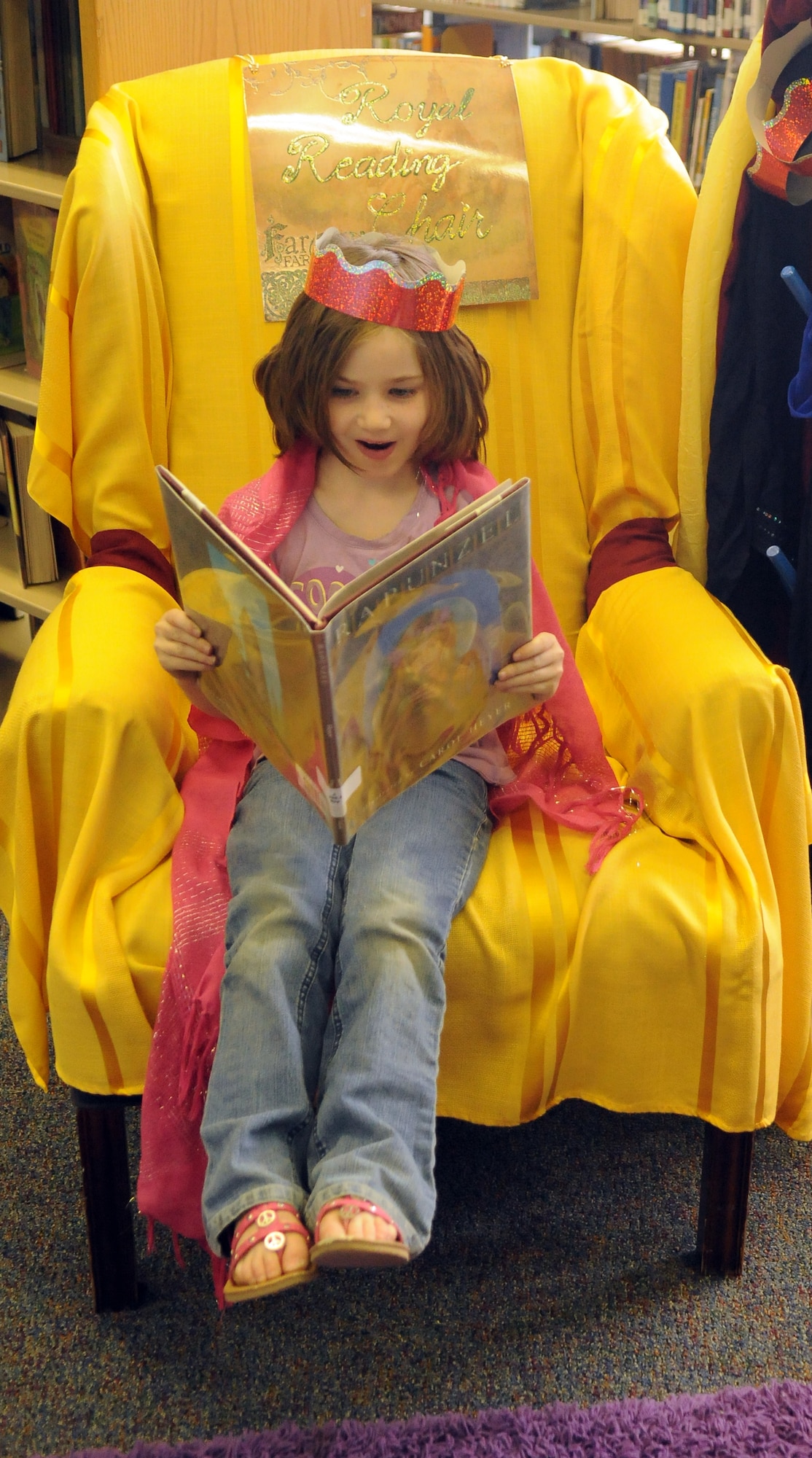Sariah Stamm reads a book on the reading throne, May 24, 2011, Eielson Air Force Base, Alaska. The Midsummer Knight's Read summer program encourages school age children to read books and rewards them with prizes. Sariah is the daughter of Staff Sgt. Aaron Stamm, 354th Maintenance Squadron avionics production supervisor. (U.S. Air Force photo/Airman 1st Class Janine Thibault)