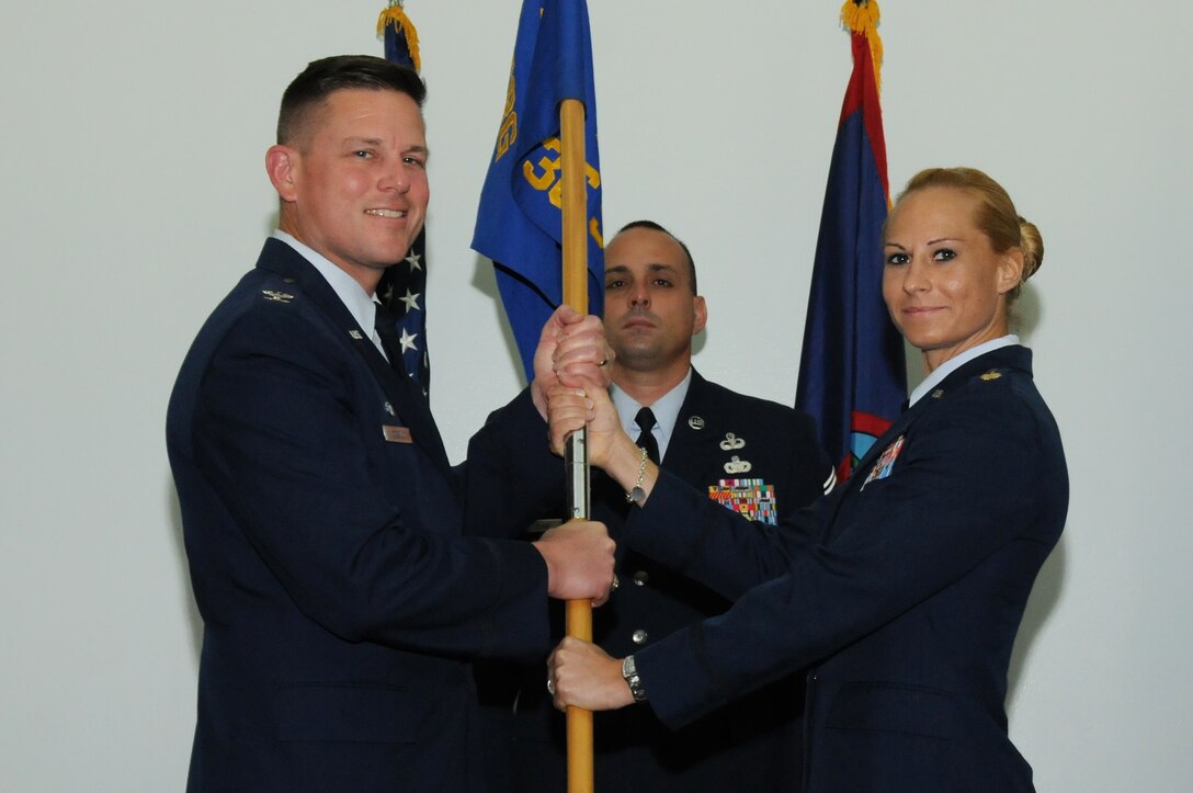 Col. Theodore Corallo, 36th Contingency Response Group commander (Left), passes the 736th Security Forces Squadron guidon to Maj. Tara Opielowski (right), newly appointed 736th SFS commander, during a change of command ceremony here May  26.(U.S. Air Force photo/ Senior Airman Carlin Leslie)
