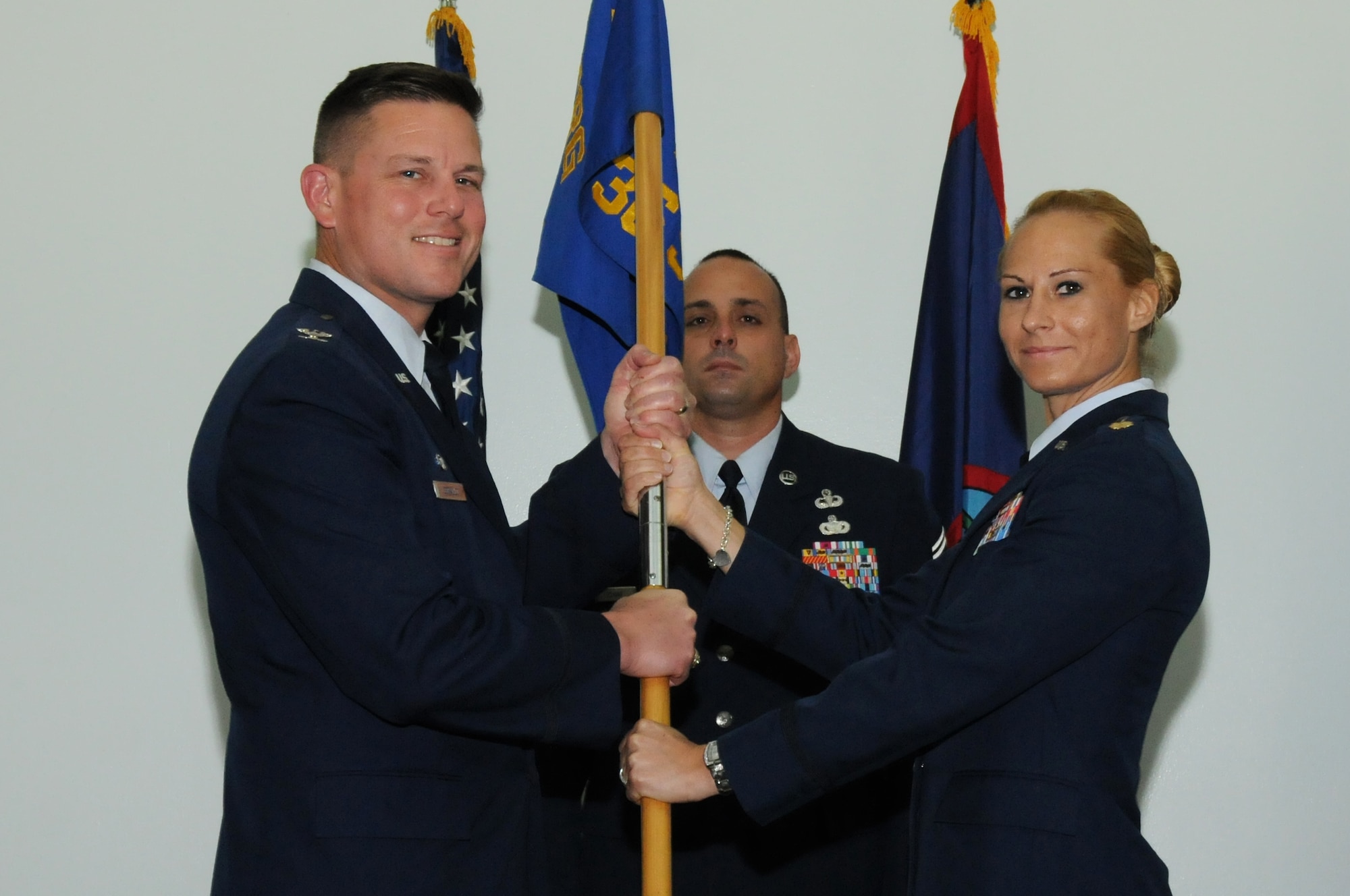 Col. Theodore Corallo, 36th Contingency Response Group commander (Left), passes the 736th Security Forces Squadron guidon to Maj. Tara Opielowski (right), newly appointed 736th SFS commander, during a change of command ceremony here May  26.(U.S. Air Force photo/ Senior Airman Carlin Leslie)
