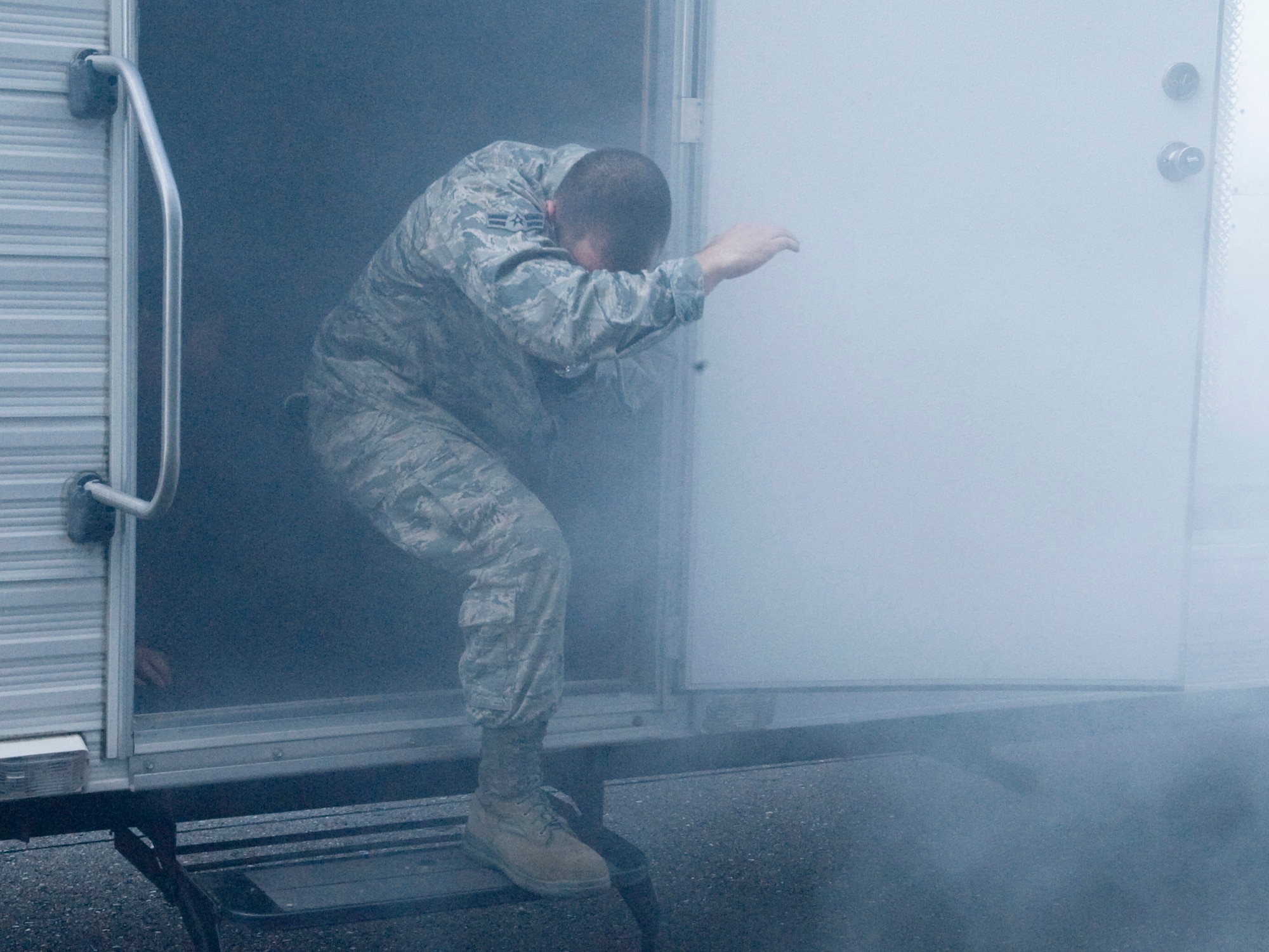 Airman 1st Class Nicholas Belair escapes a simulated burning trailer at the annual summer safety fair May 26, 2011, Eielson Air Force Base, Alaska. Eielson personnel navigated a fire safety house learning invaluable lessons on how to escape a burning building.  Airman Belair is a fire fighter assigned to the 354th Civil Engineer Squadron, Fire Protection Flight. (U.S. Air Force photo/Airman 1st Class Laura Goodgame) 