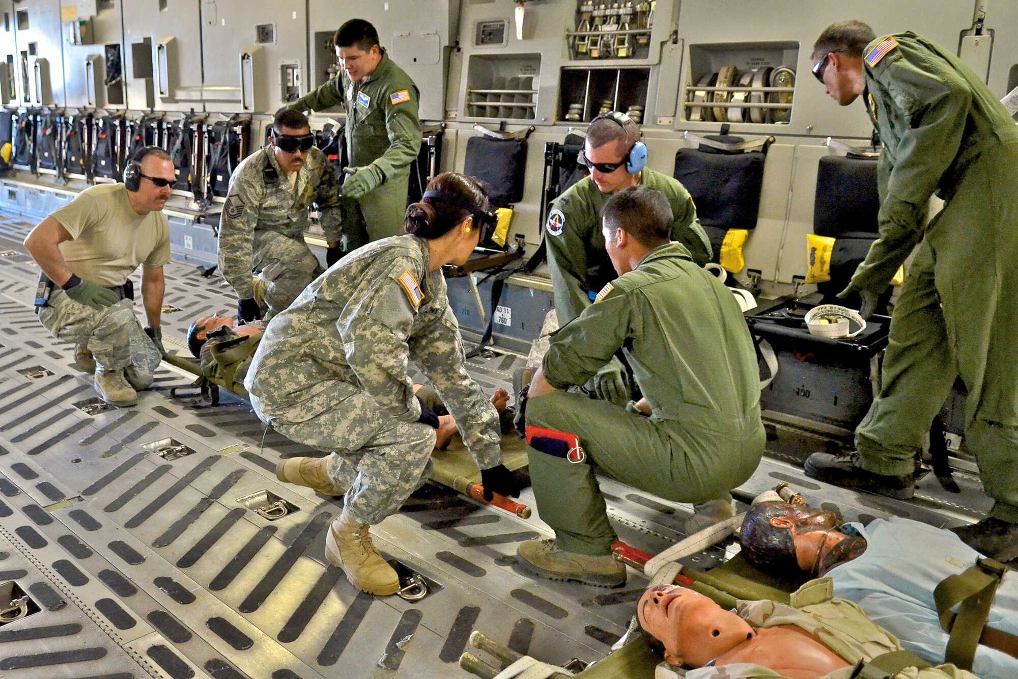 U.S. Air Force flight medics with the 446th Aeromedical Evacuation Squadron, Joint Base Lewis-McChord, Wash., direct Army and Air Force medical personnel loading a simulated casualty on a C-17 Globemaster aircraft at Schoonover Airfield, Fort Hunter Liggett, Calif., May 20, 2011, in support of Global Medic 2011 and Warrior 91 11-01. Global Medic is a joint field training exercise for theater aeromedical evacuation system and ground medical components designed to replicate all aspects of combat medical service support. Warrior Exercise gives participating units an opportunity to rehearse military maneuvers and tactics such as security, convoy operations and quick reaction drills during simulated enemy attacks. (U.S. Air Force photo by Senior Airman Raymond A. Estes/Released)