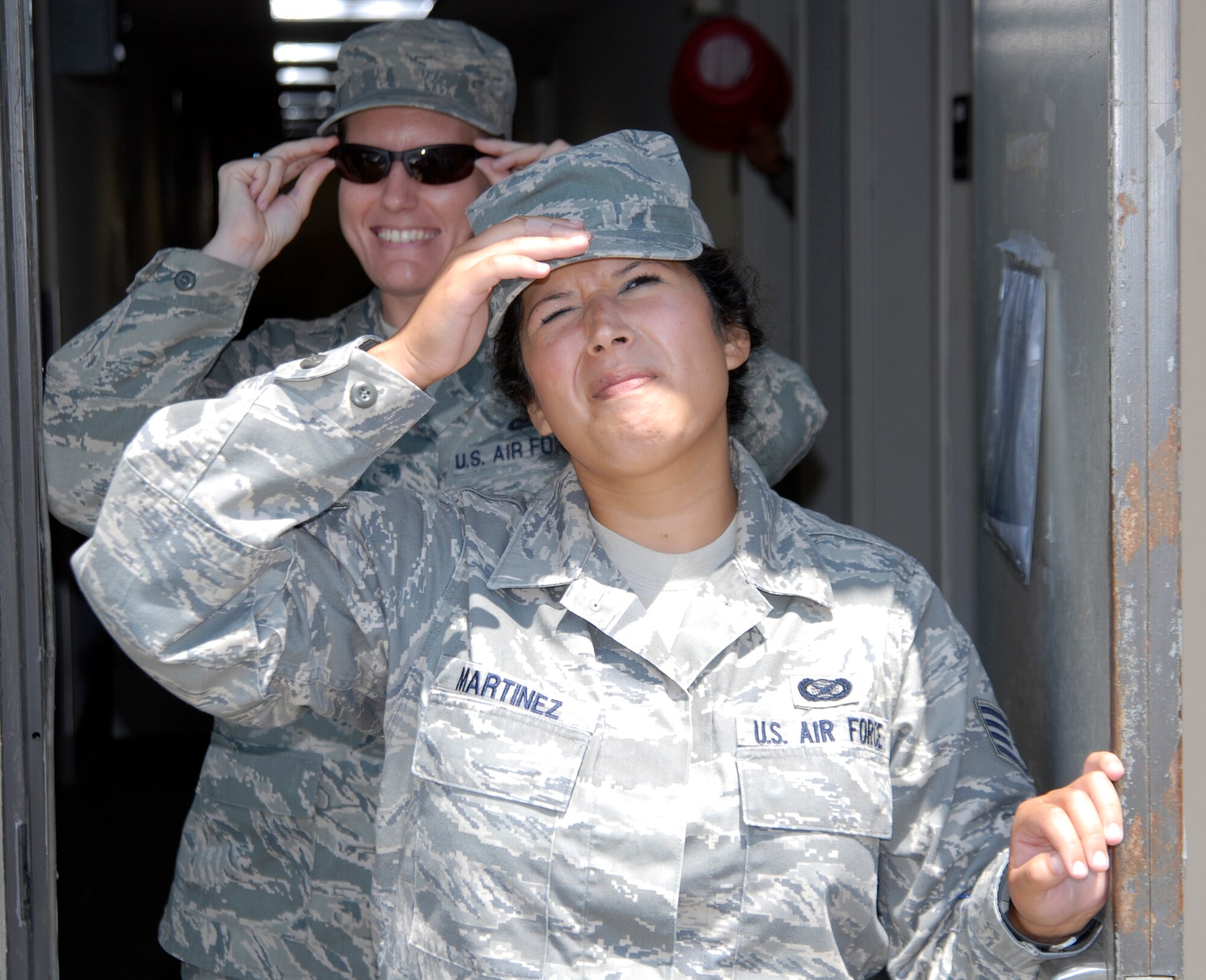 Staff Sgt. Sarah Martinez, 1st Special Operations Wing Public Affairs, tries to shield her eyes from the sun as Tech. Sgt. Stacy Fowler, 1st SOW/PA, puts on her sunglasses while leaving their office at Hurlburt Field, Fla., May 31, 2011. Wearing sunglasses can play a major role in protecting the eyes from ultraviolet radiation. (U.S. Air Force photo by Senior Airman Joe McFadden / RELEASED)