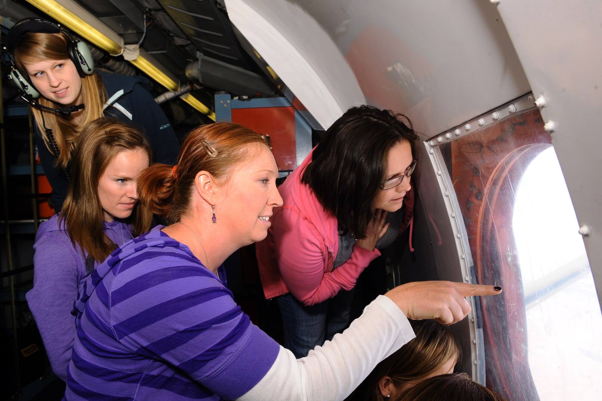 OFFUTT AIR FORCE BASE, Neb. - 45th Reconnaissance Spouses look out of the circular port side window on the OC-135B Open Skies aircraft as they fly over Denver, Colo. as part of a incentive flight here, May 21. Forty seats on two separate flights were reserved for the spouses of the 45th RS Airmen in order for them to get a first hand look at their spouse's daily operations.  The OC-135B routinely travels across Russia and many other Open Skies Treaty signatory nations photographing areas of interest to the Defense Threat Reduction Agency. U.S. Air Force Photo by Josh Plueger (released)