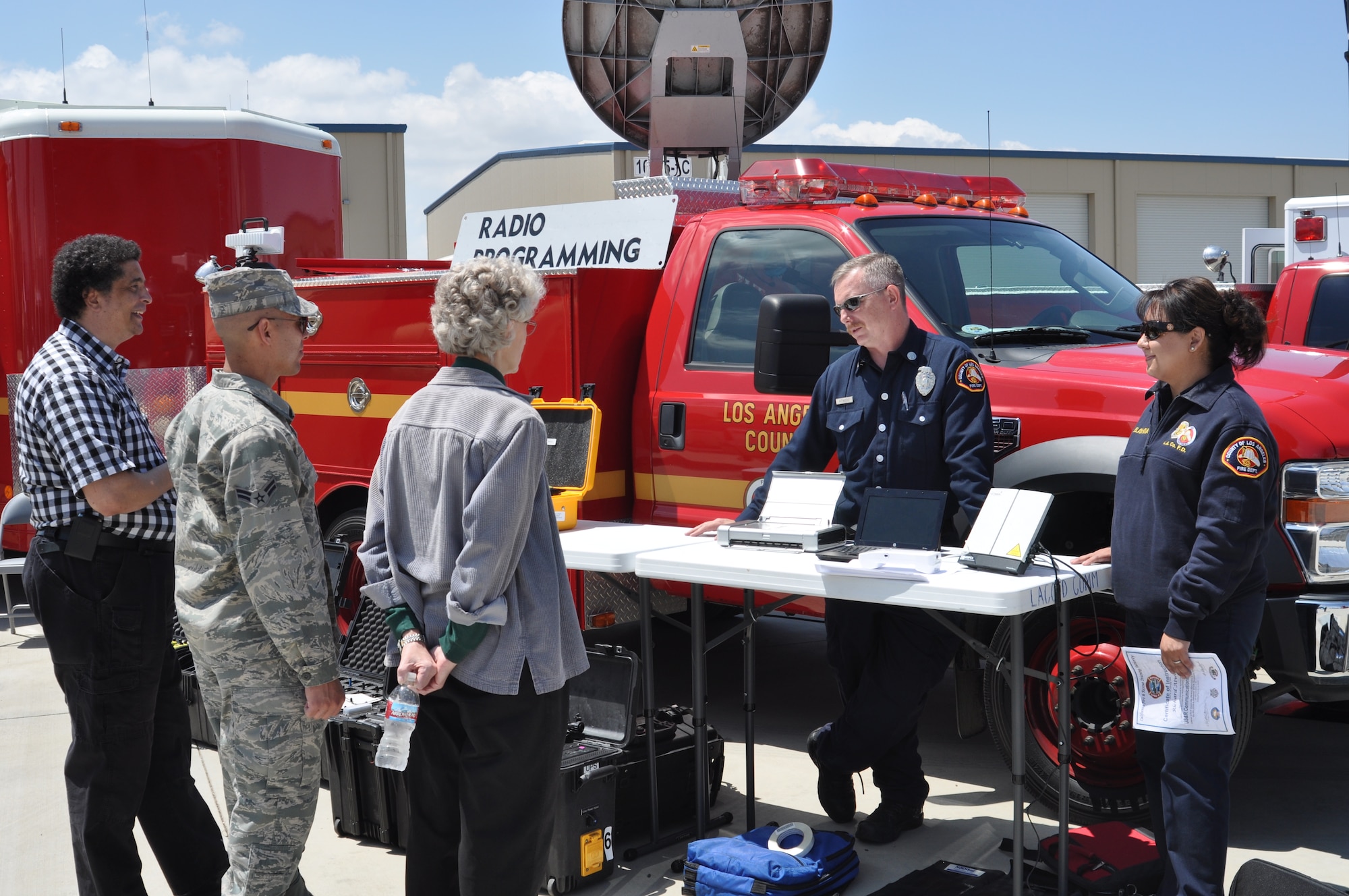 (from left) Barry Cannon, 452nd Communications Squadron; Airman 1st Class David Adolfo, 452nd Emergency Management Flight; and Nancy Driscoll, chief of bioenvironmental engineering and public health at March Air Reserve Base, exchange communication equipment ideas with Capt. Rich Atwood and fire dispatcher Barbara Selayndia of the Los Angeles County Fire Department .  The 3rd Annual Riverside County Multi-Agency Communication Interoperability Test was held at the Ben Clark Training Center in Riverside, Calif., May 19, 2011.  (U.S. Air Force photo/ Megan Just)