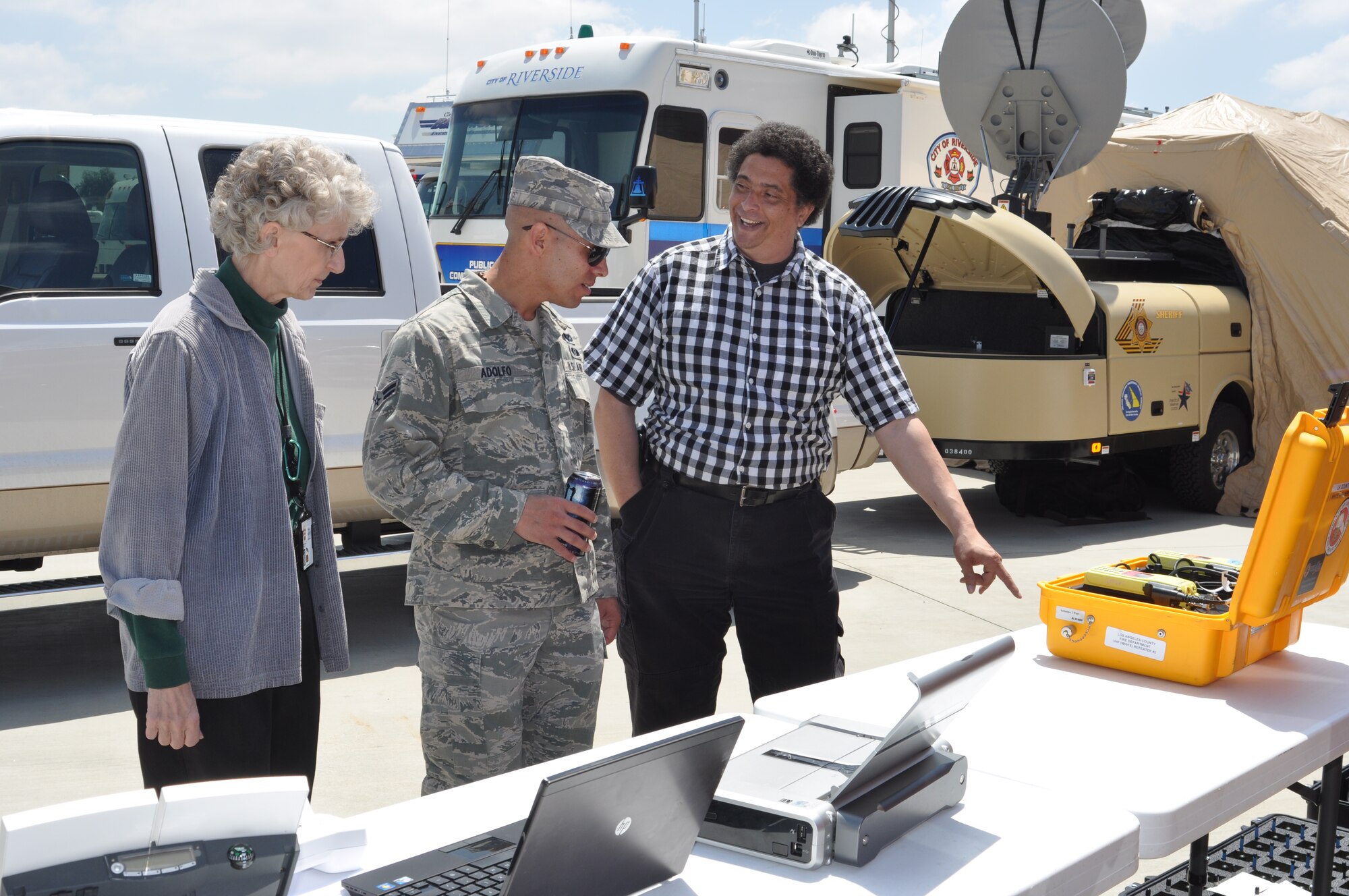 (from right) Barry Cannon, 452nd Communications Squadron, discusses communication equipment on display at the 3rd Annual Riverside County Multi-Agency Communication Interoperability Test with Airman 1st Class David Adolfo, 452nd Emergency Management Flight, and Nancy Driscoll, chief of bioenvironmental engineering and public health at March Air Reserve Base.  The interoperability test was held at the Ben Clark Training Center in Riverside, Calif., May 19, 2011.  (U.S. Air Force photo/ Megan Just)