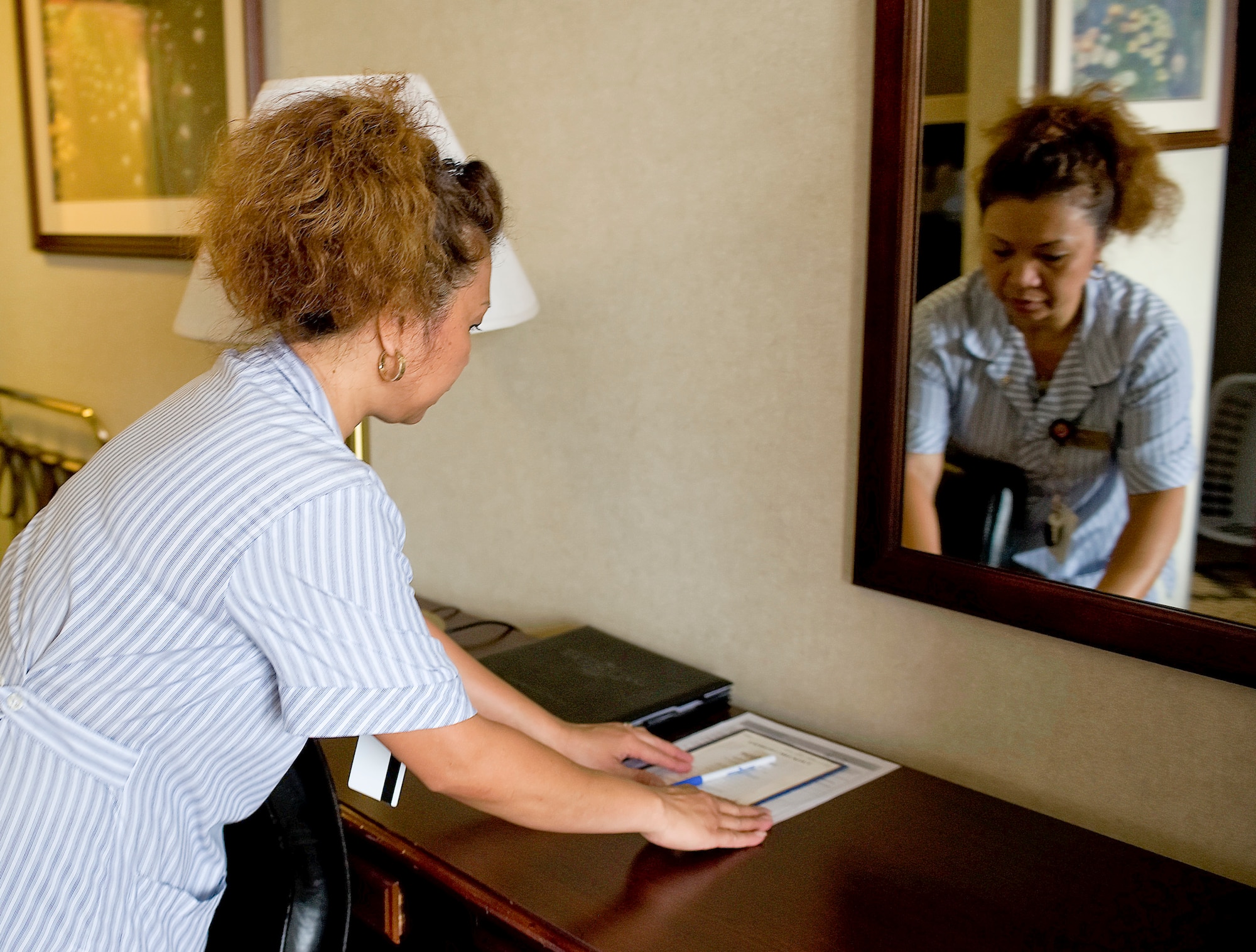 Belma Kadunce, Eagle’s Rest housekeeper, straightens up the business desk in a visiting quarters room May 26, 2011, at Dover Air Force Base, Del. (U.S. Air Force photo by Steve Kotecki)