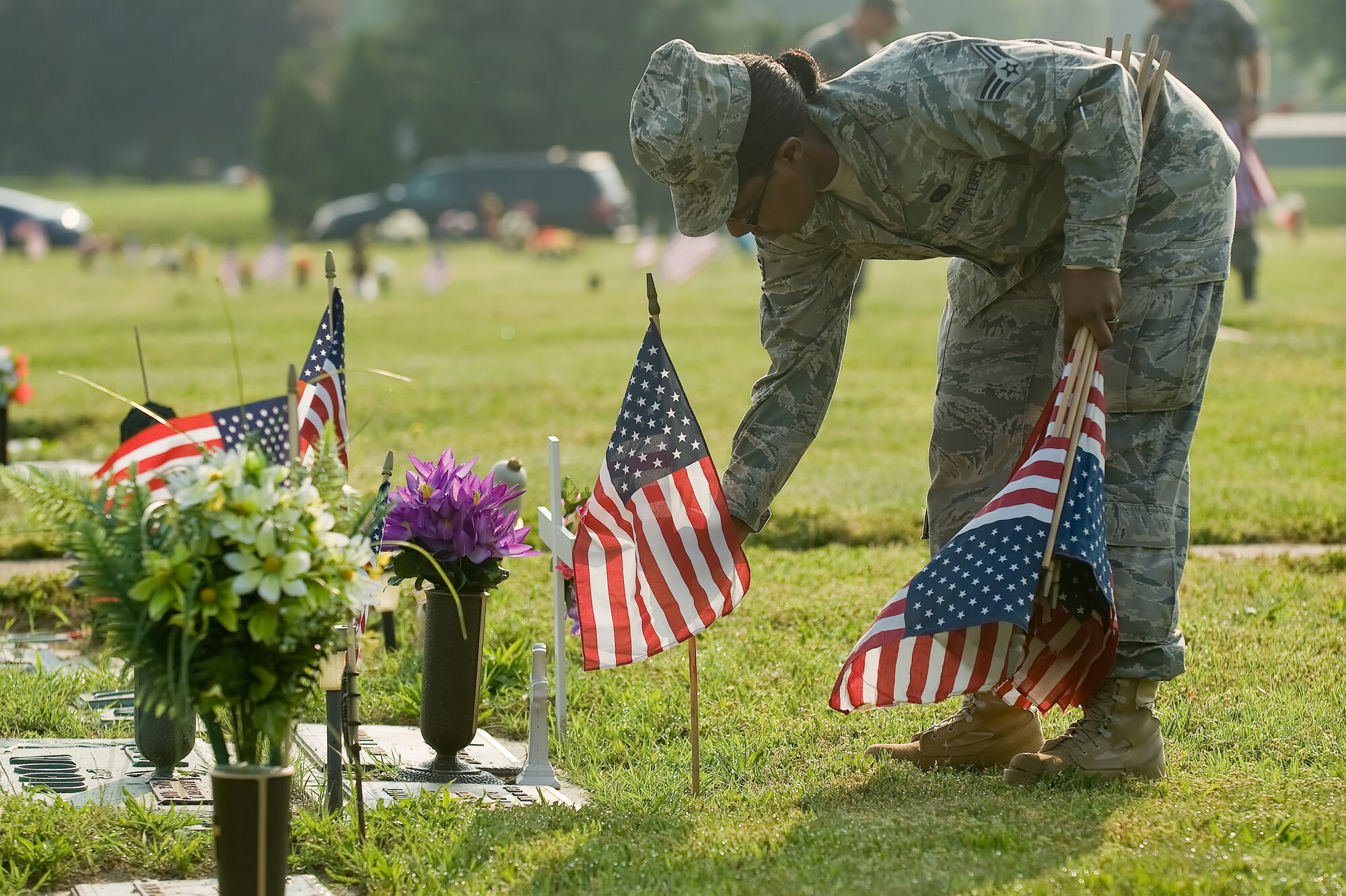 Senior Airman Shameika Housley, 436th Aerial Port Squadron mobility flight supply representative, places an American flag on a gravesite of a deceased military member May 26, 2011, at Sharon Hill Cemetery in Dover, Del.  The American Legion Post No. 2 coordinated the event in honor of Memorial Day and Team Dover members helped accomplish the mission. (U.S. Air Force photo by Adrian Rowan)