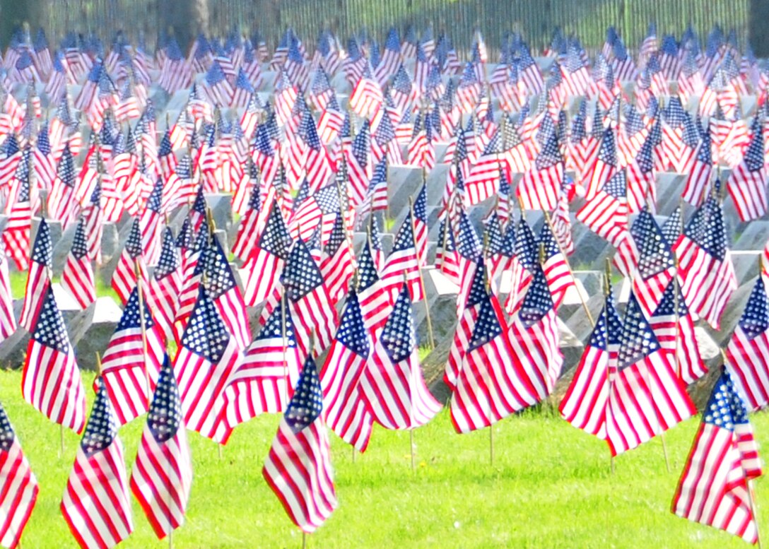 Volunteers place American flags during a Memorial Day ceremony held at Forest Lawn Cemetery, May 30, 2011, Buffalo, NY. During the morning thousands of flags where placed next to those men and woman who died while serving the United States military. (U.S. Air Force photo by Staff Sgt. Joseph McKee)