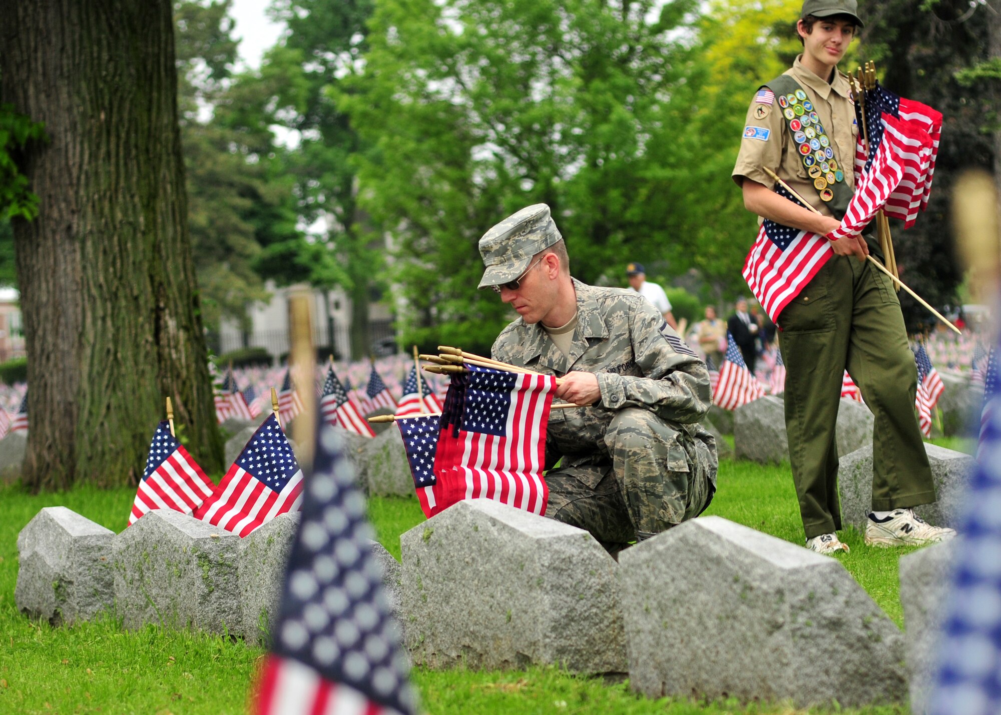 Master Sgt. Kevin Nichols places an American flag the grave of a veteran during a Memorial Day ceremony held at Forest Lawn Cemetery, May 30, 2011, Buffalo, NY. During the morning thousands of flags where placed next to those men and woman who died while serving the United States military. (U.S. Air Force photo by Staff Sgt. Joseph McKee)