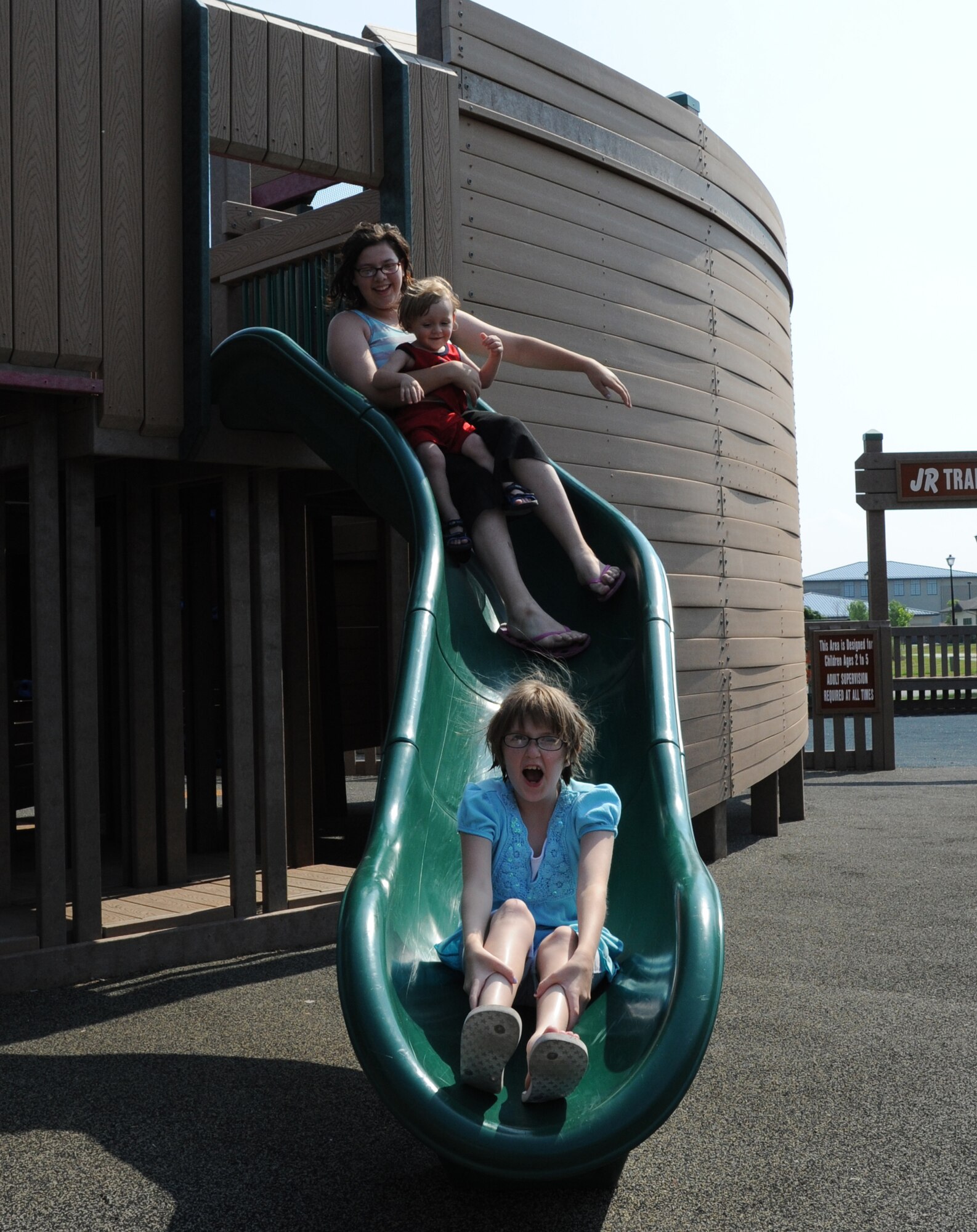 (From top) Chelsea, Dakota and Beonca Abbott, the grandchildren of Air Force retiree Young Morin, go down the slide at Liberty Park May 30, 2011, at Dover Air Force Base, Del. (U.S. Air Force photo by Staff Sgt. Chad Padgett)