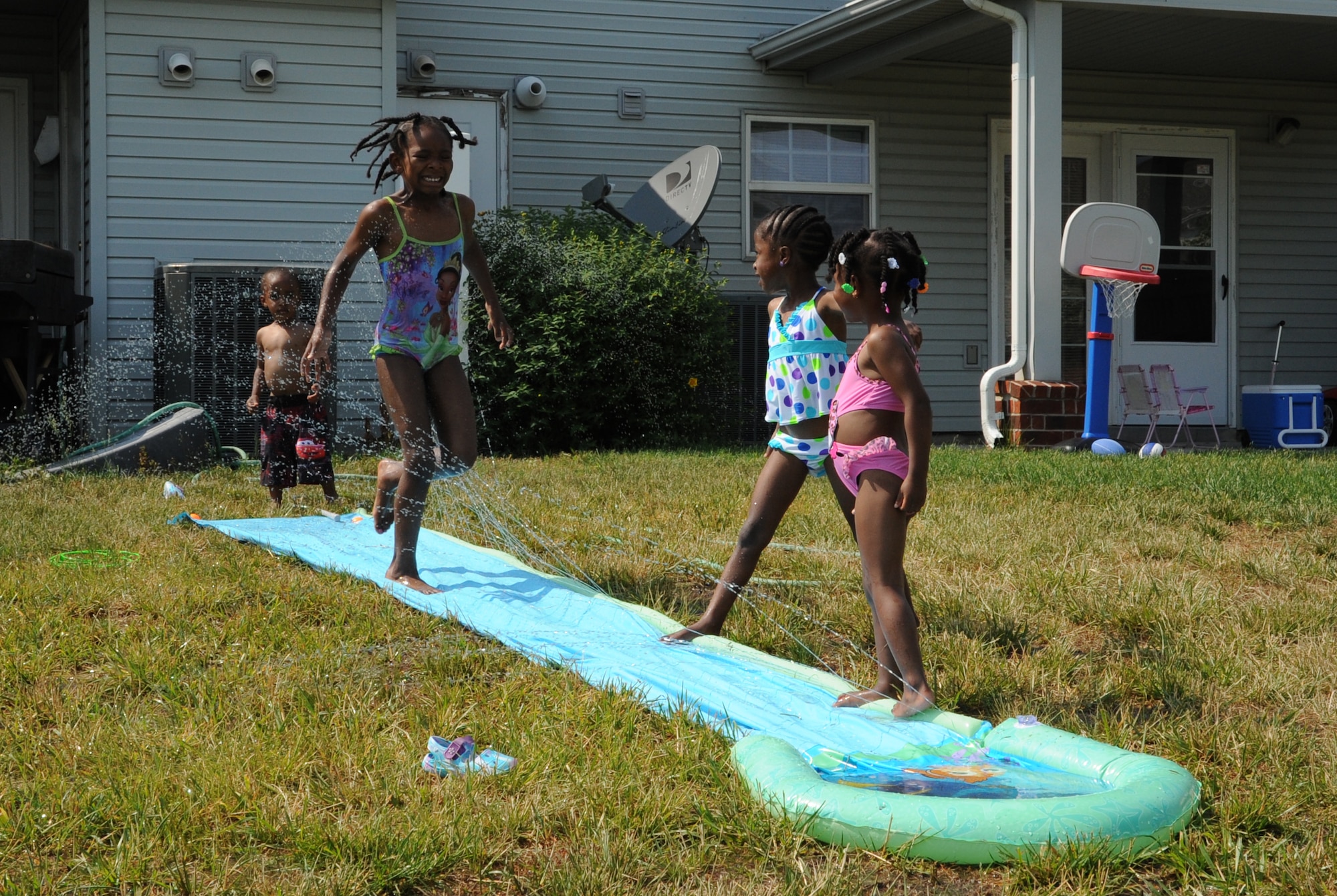 (From left) JB, Kaniya, Brely and Sidney Shropshire, the children of Army Staff Sgt. Gregory Shropshire, 233 Transportation Company, play with water toys in their back yard to try and beat the summer heat May 30, 2011, at Dover Air Force Base, Del.  (U.S. Air Force photo by Staff Sgt. Chad Padgett)