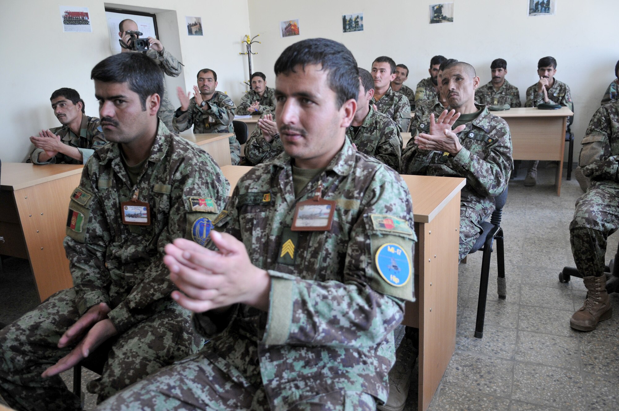 Afghan firefighter trainees show their excitement after Master Sgt. Edward Nowak presented Nomex fire-protection hoods inside the Afghan air force fire fighting training complex May 28, 2011, in Kabul, Afghanistan. The Nomex hoods were donated by the Robeson County Firefighters Association in Parkton, N.C. Sergeant Nowak is a 440th Air Expeditionary Advisory Squadron C-27 production superintendent adviser and volunteer firefighter. (U.S. Air Force photo/Tech. Sgt. Brian E. Christiansen)

