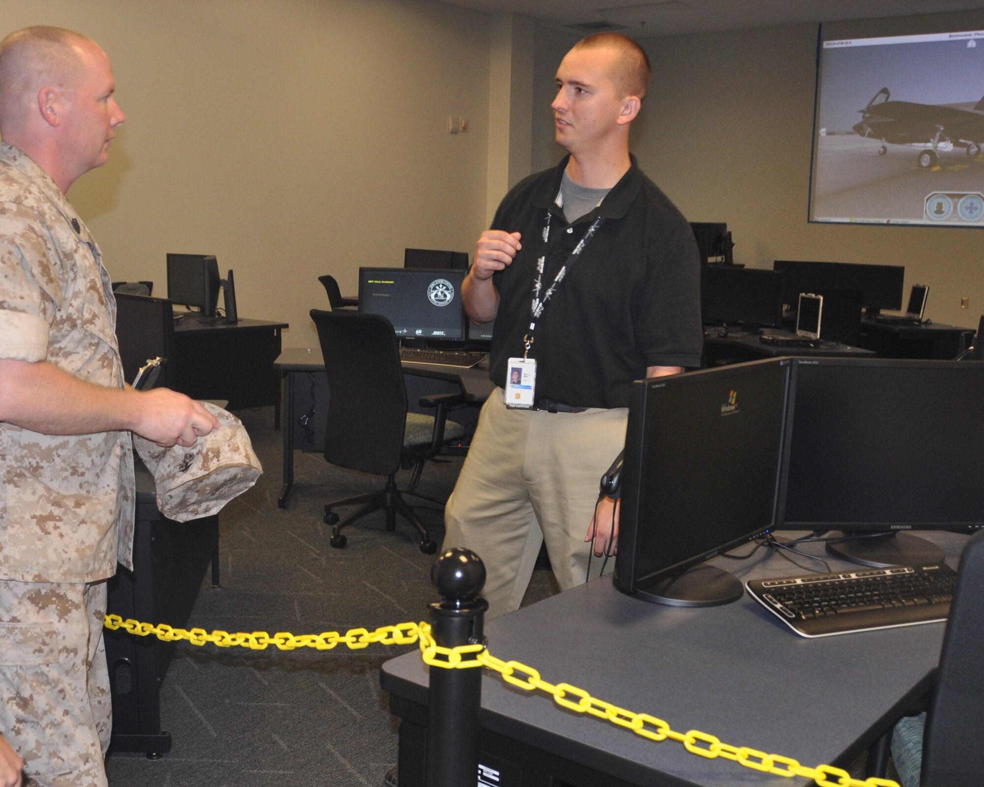 Eric Litton, F-35 Academic Training Center instructor, explains the phases of maintenance training to Gunnery Sergeant Trey Coon, 33rd Maintenance Group quality assurance NCO in charge, during the 33rd Fighter Wing's open house for members May 27. The sergeant and his wife, Rebecca, had the first time opportunity to look at the virtual classroom set up for F-35 maintainers. Mr. Litton said academics are step one before entering the classroom to conduct maintenance tasks using an avatar on screen with an electronic work order. According to the current syllabus, hands on training will begin in simulators and on the flight line after tasks are perfected in cyberspace. (U.S. Air Force photo/Chrissy Cuttita)

