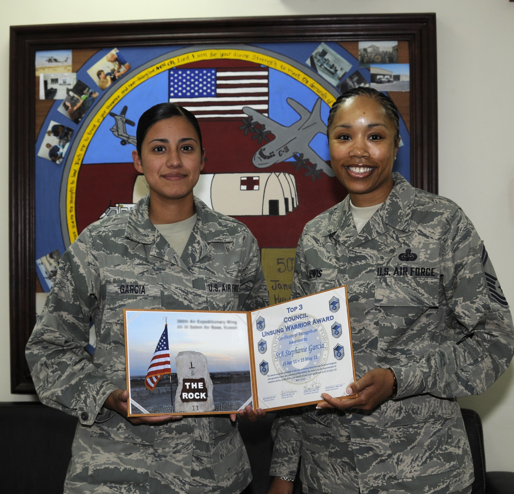 Senior Airman Stephanie Garcia, left, is presented the 386th Air Expeditionary Wing Top III Council's Unsung Warrior award by Senior Master Sgt. Cheree Lewis. Airman Garcia is a member of the 386th Expeditionary Medical Group. The award is given in two categories, Airmen and NCO, to individuals who "genuinely inspire and contribute (often behind the scenes) to the improvement of customer service, quality of life and overall mission accomplishment at the 386th AEW." (U.S. Air Force photo by Capt. Heath Allen)