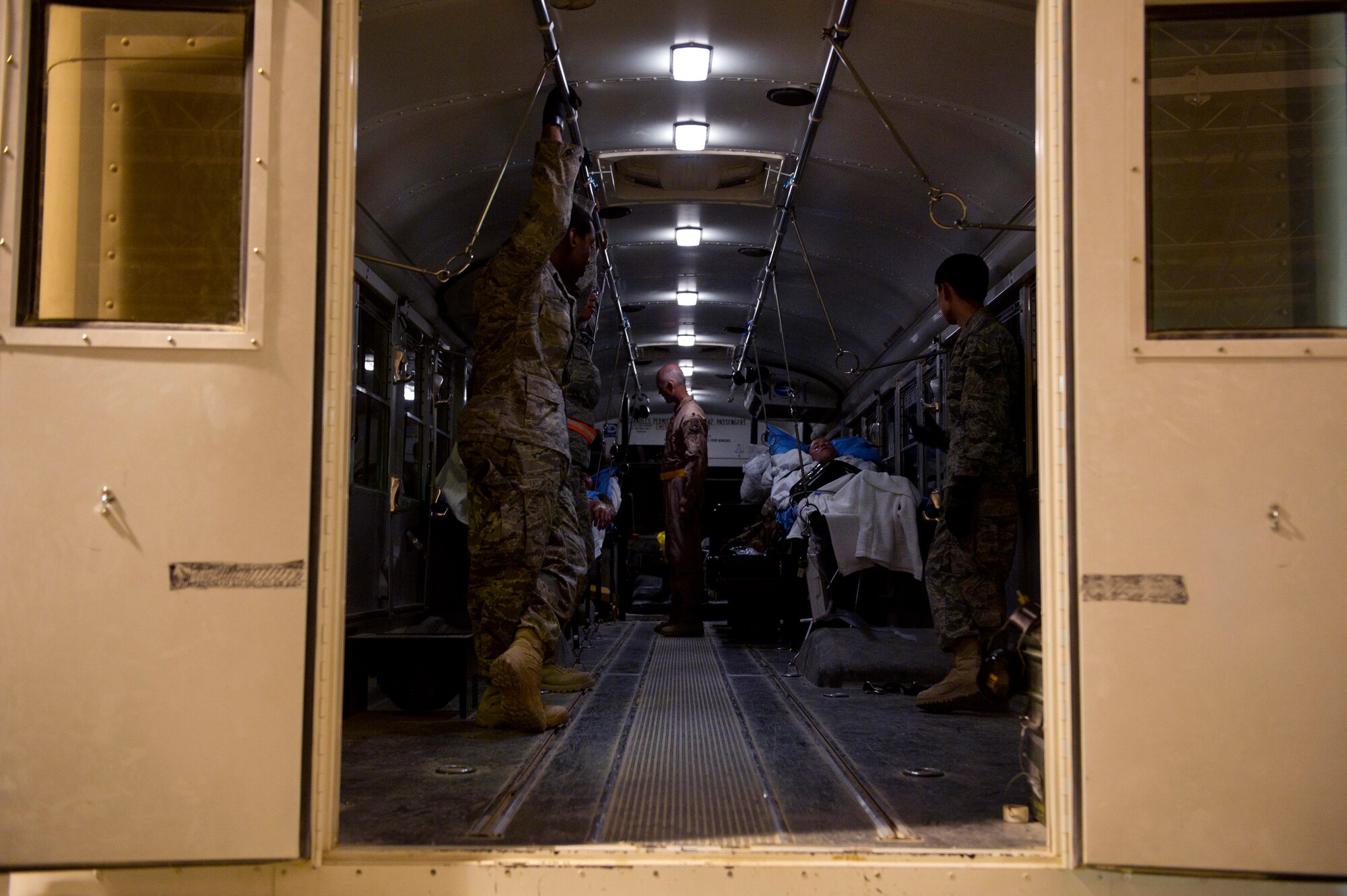 Members of the 451st Expeditionary Aeromedical Evacuation Squadron Detachment 1 Contingency Aeromedical Staging Facility look after wounded Marines on an ambulance bus at Camp Bastion, Afghanistan, as they wait to load other wounded Marines. The CASF team is responsible for taking care of and transporting patients from the staging facility and role hospital to aircraft who are then transported to the next level of medical care. (U.S. Air Force photo by Master Sgt. Adrian Cadiz)