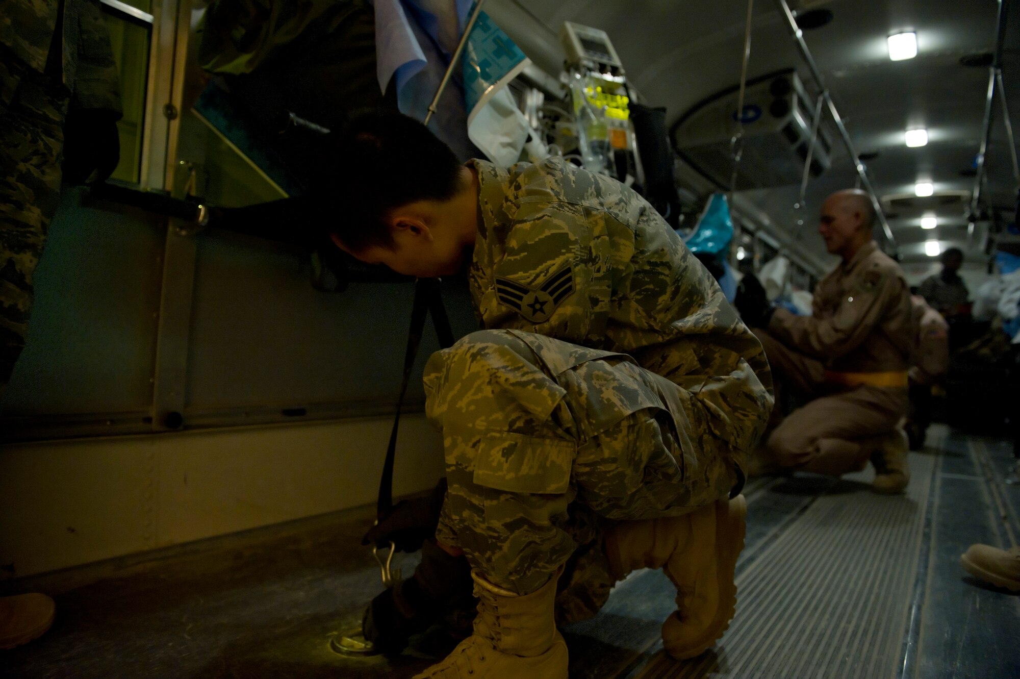 Senior Airman Hoang Nguyen, 451st Expeditionary Aeromedical Evacuation Squadron Detachment 1 Contingency Aeromedical Staging Facility, aerospace medical technician, secures a litter of a wounded Marine onto an ambulance bus at Camp Bastion, Afghanistan, in order to transport him to a waiting C-130 Hercules. The CASF team is responsible for taking care of and transporting patients from the staging facility and role hospital to aircraft who are then transported to the next level of medical care. Airman Nguyen is deployed from the 88th Medical Operations Squadron, Wright-Patterson AFB, Ohio. (U.S. Air Force photo by Master Sgt. Adrian Cadiz)
