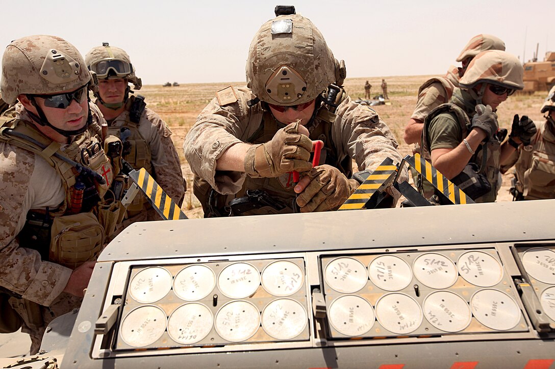 U.S. Marine Corps Staff Sgt. Daniel Pare carefully works to pry flares out of a downed French F-2000 Mirage during a recovery mission in the Bakwa District, Afghanistan, May 27, 2011. Pare is assigned to the 2nd Explosive Ordnance Disposal Company, 2nd Marine Logistics Group.
