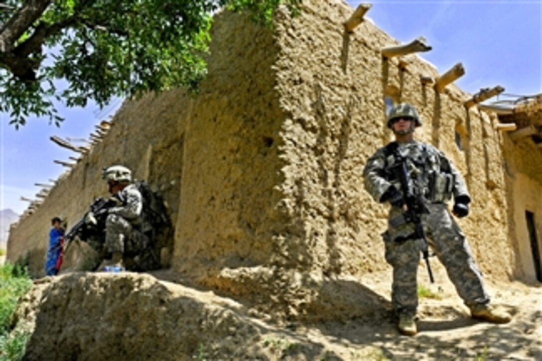 U.S. Army Spc. Myles Gaudet (left) and Spc. Matthew Tempesta provide security as members of Provincial Reconstruction Team Zabul, Arghandab detachment, meet with elders from Deh Afghanan village, Afghanistan, on May 27, 2011.  Gaudet and Tempesta are assigned to the team's security force.  