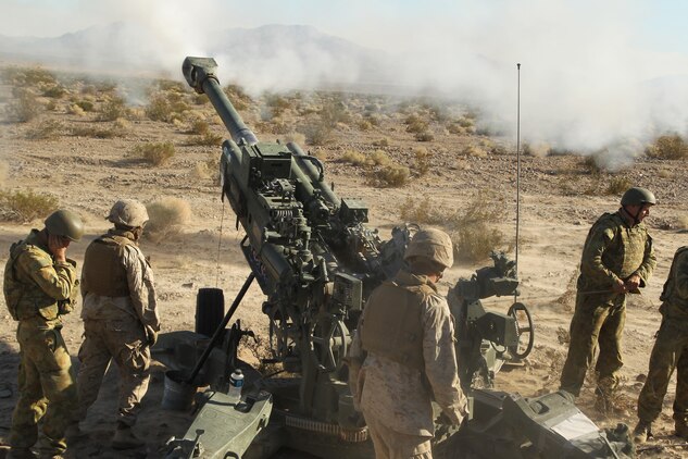 Marines with Battery I, 3rd Battalion, 11th Marine Regiment, and Australian soldiers with 1st Brigade, 8/12, work in tandem to fire the M777 howitzer during cross training in support of Enhanced Mojave Viper Oct. 26, 2011, at Quackenbush range.